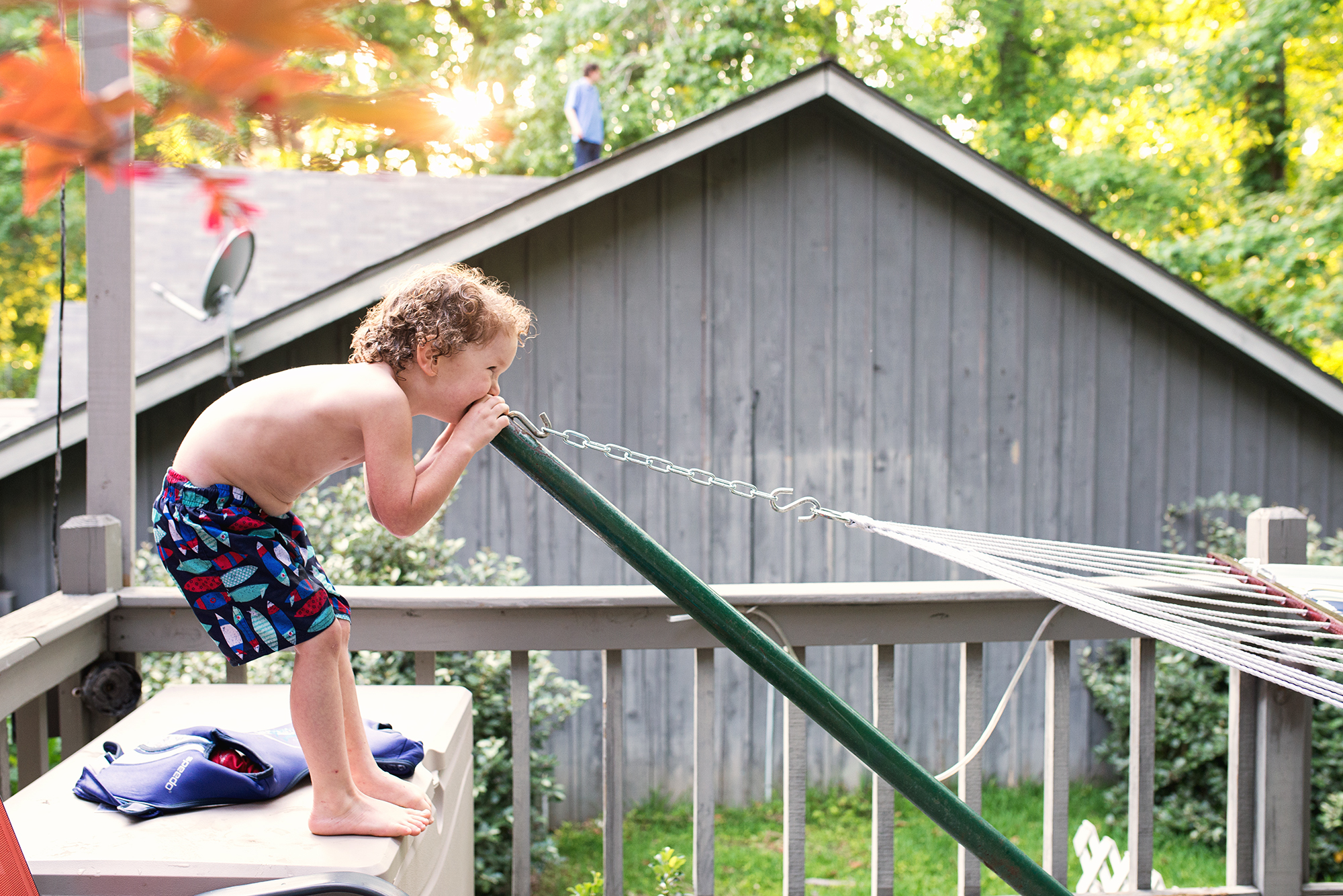boy yells in to hammock pole - Documentary family photography