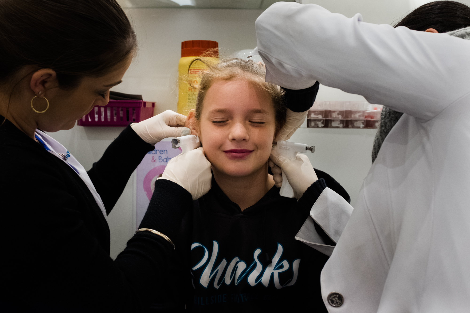 girl gets ears pierced - Documentary Family Photography