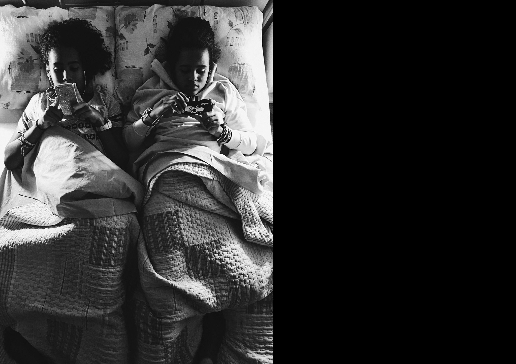 girls on phone in bed - Documentary Family Photography