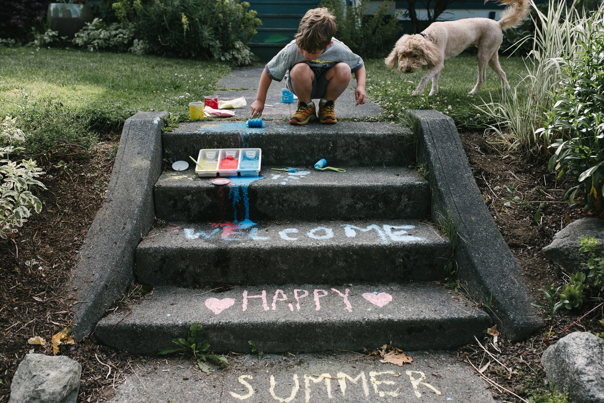 boy draws on steps with chalk - Documentary Family Photography