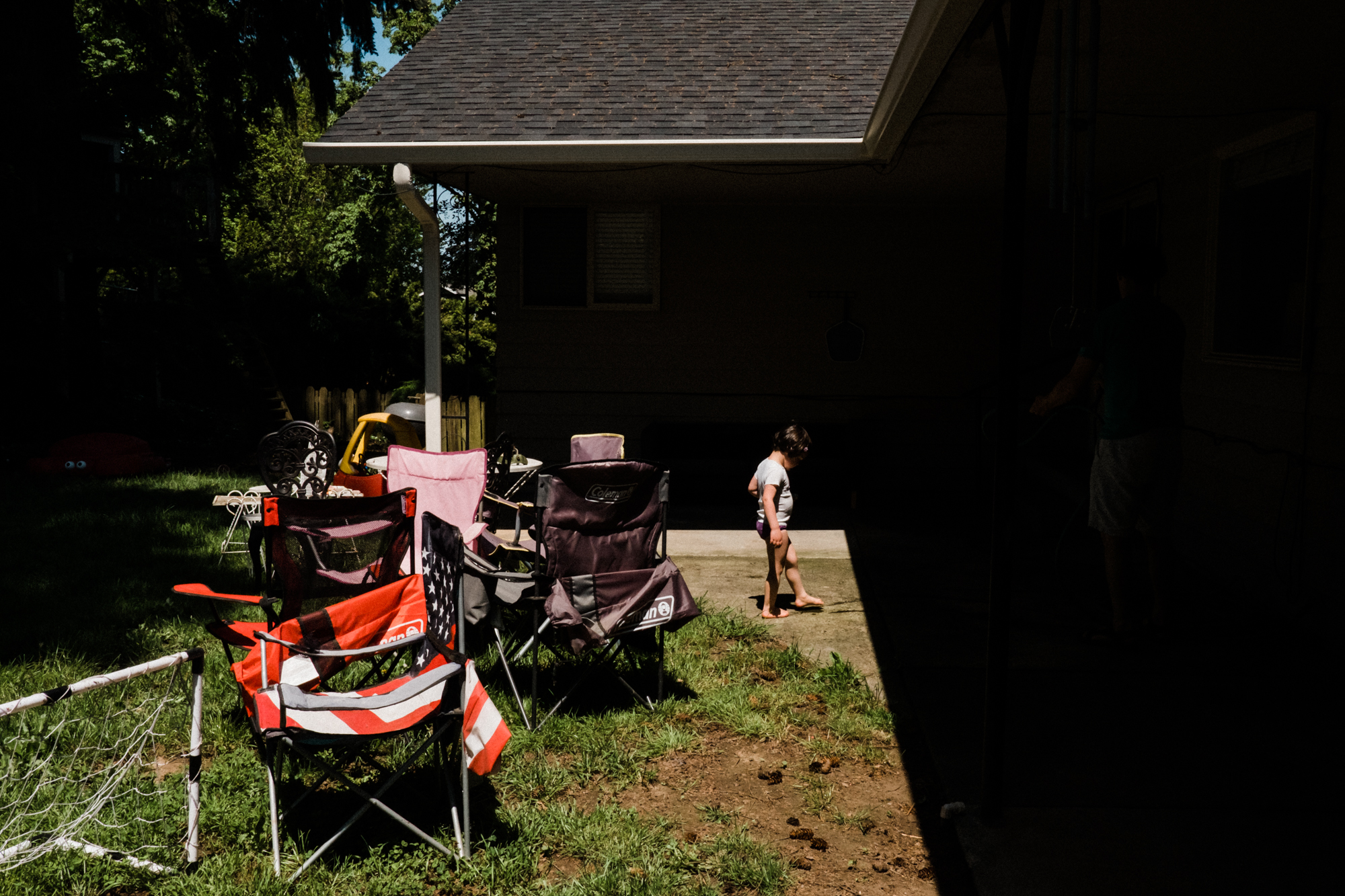 girl in backyard with lawn chairs - Documentary Family Photography