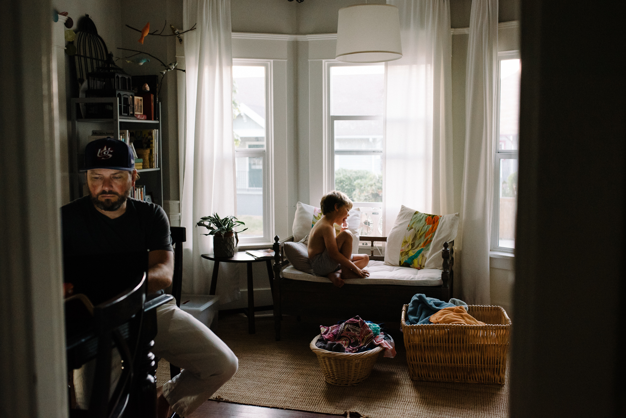 child sits in window seat - Documentary Family Photography