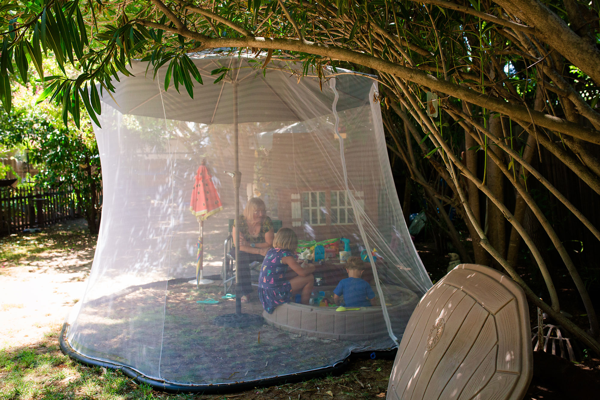 grandmother and girl in mosquito net - documentary family photography