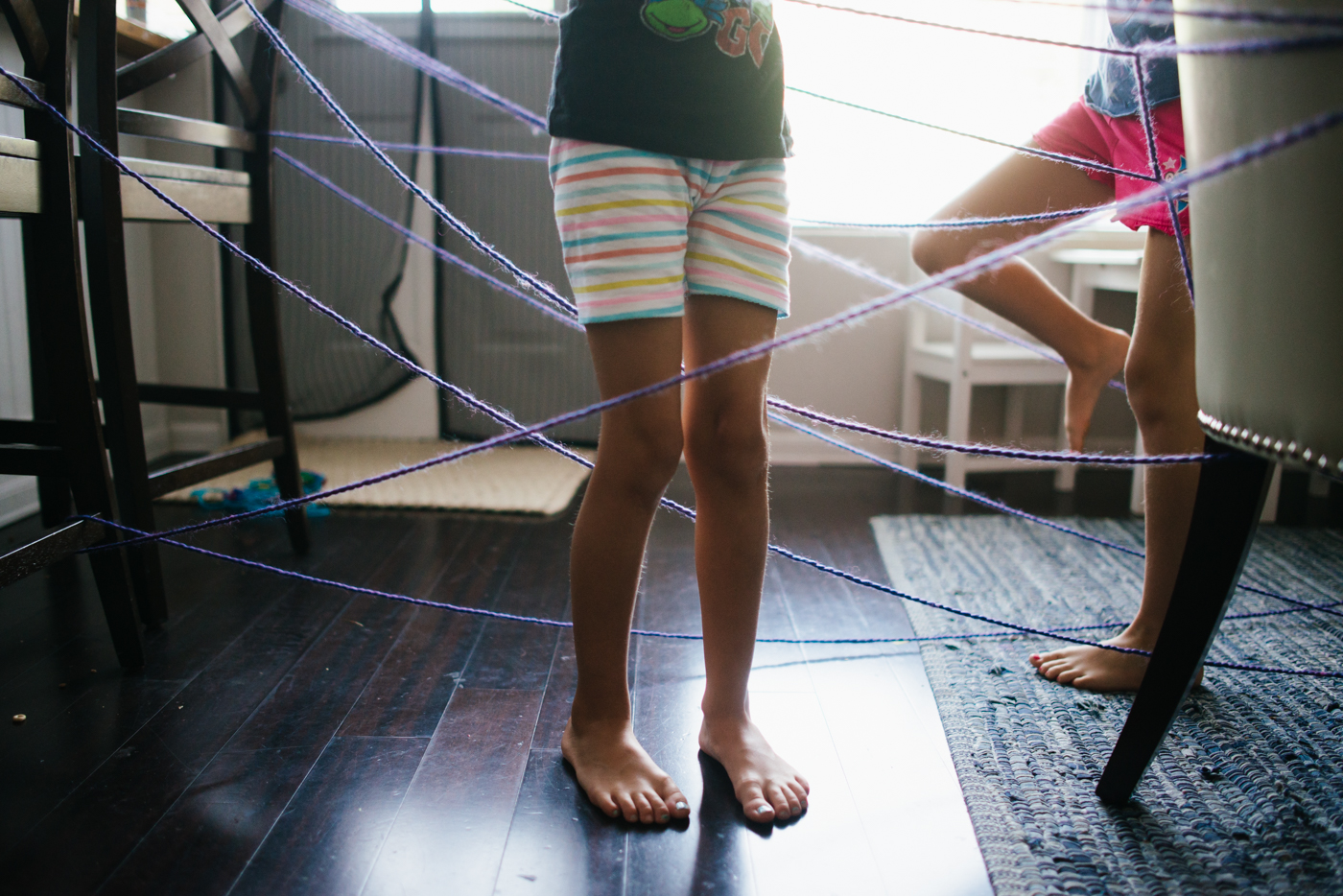 kids legs tangled in yarn - documentary family photography