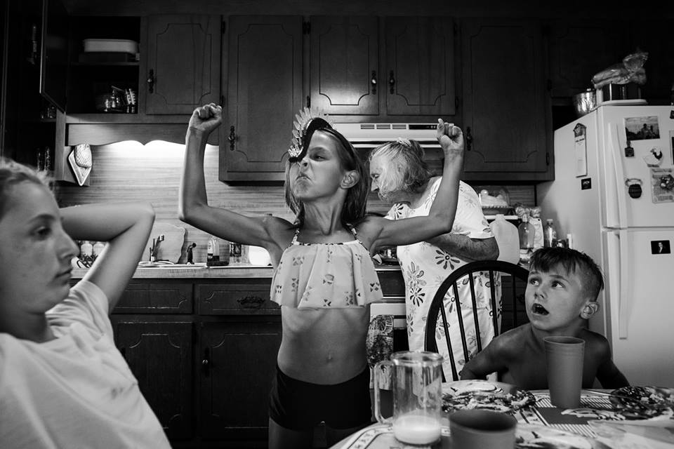 girl flexes muscles - documentary family photography