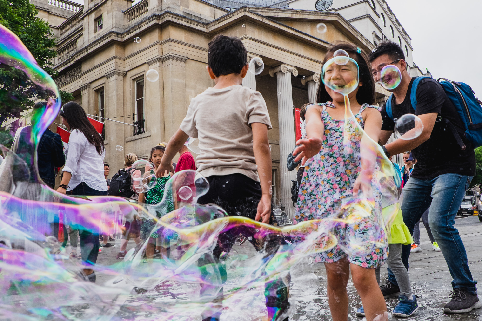 girl makes giant bubbles - Documentary Family Photography