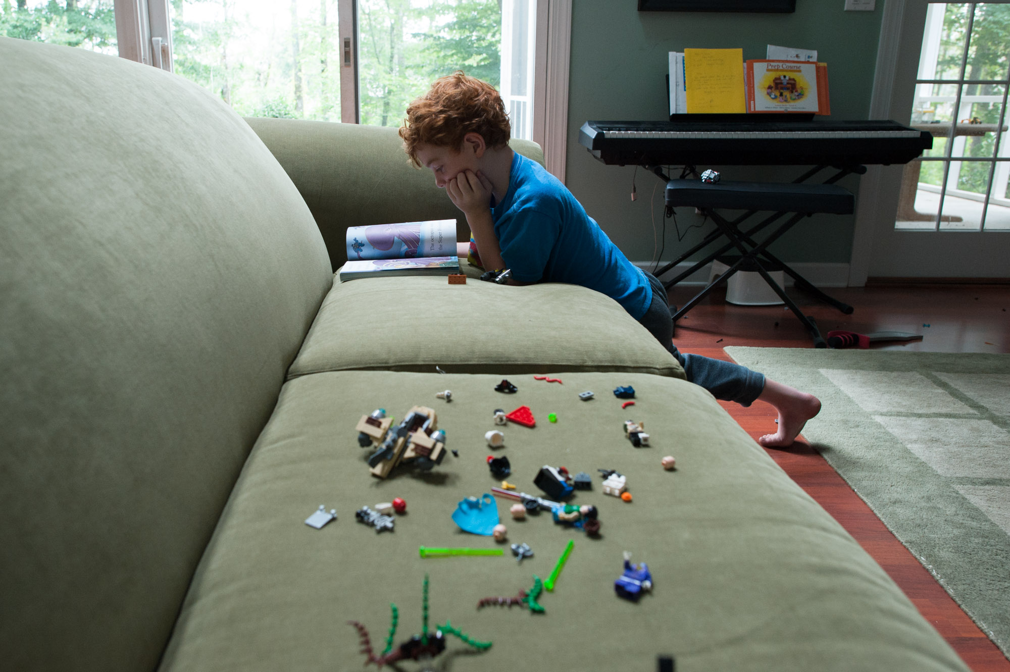 boy with toys spread along couch - Documentary Family Photography