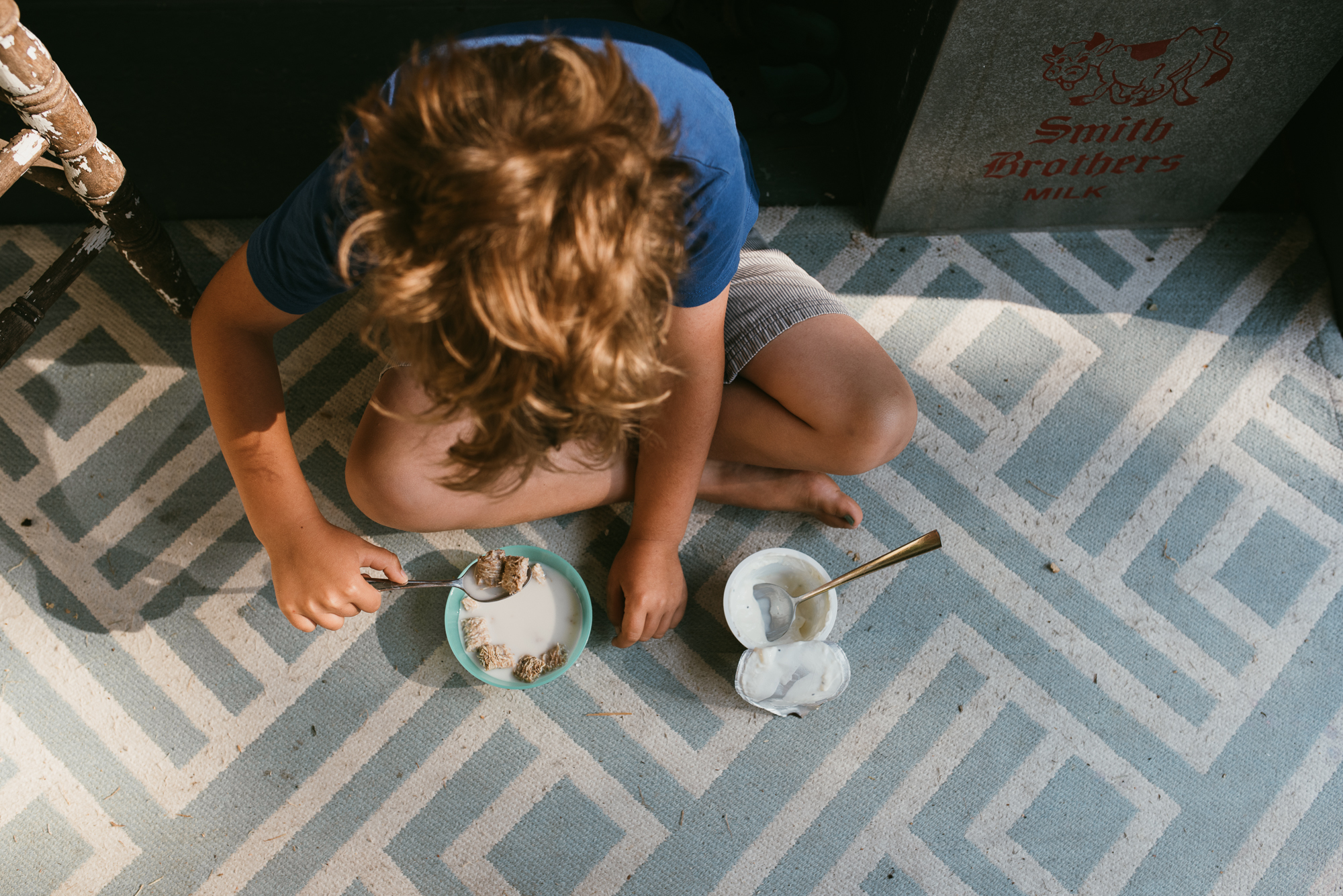 child eats breakfast on floor - documentary family photography