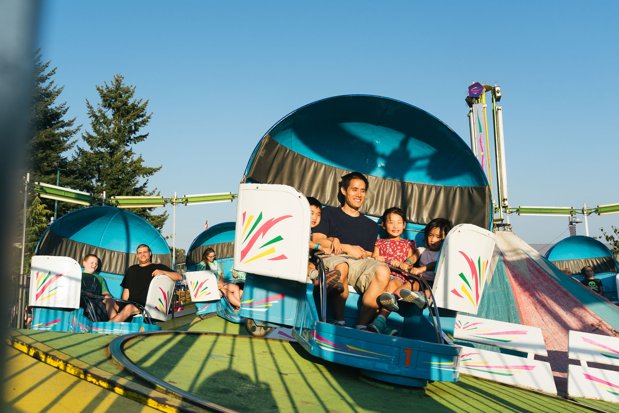 father and kids on amusement park ride - Documentary Family Photography