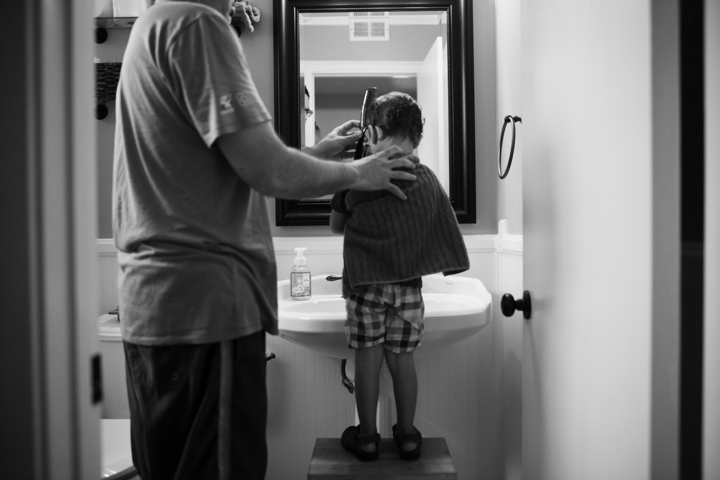 father combing boy's hair - Documentary Family Photography