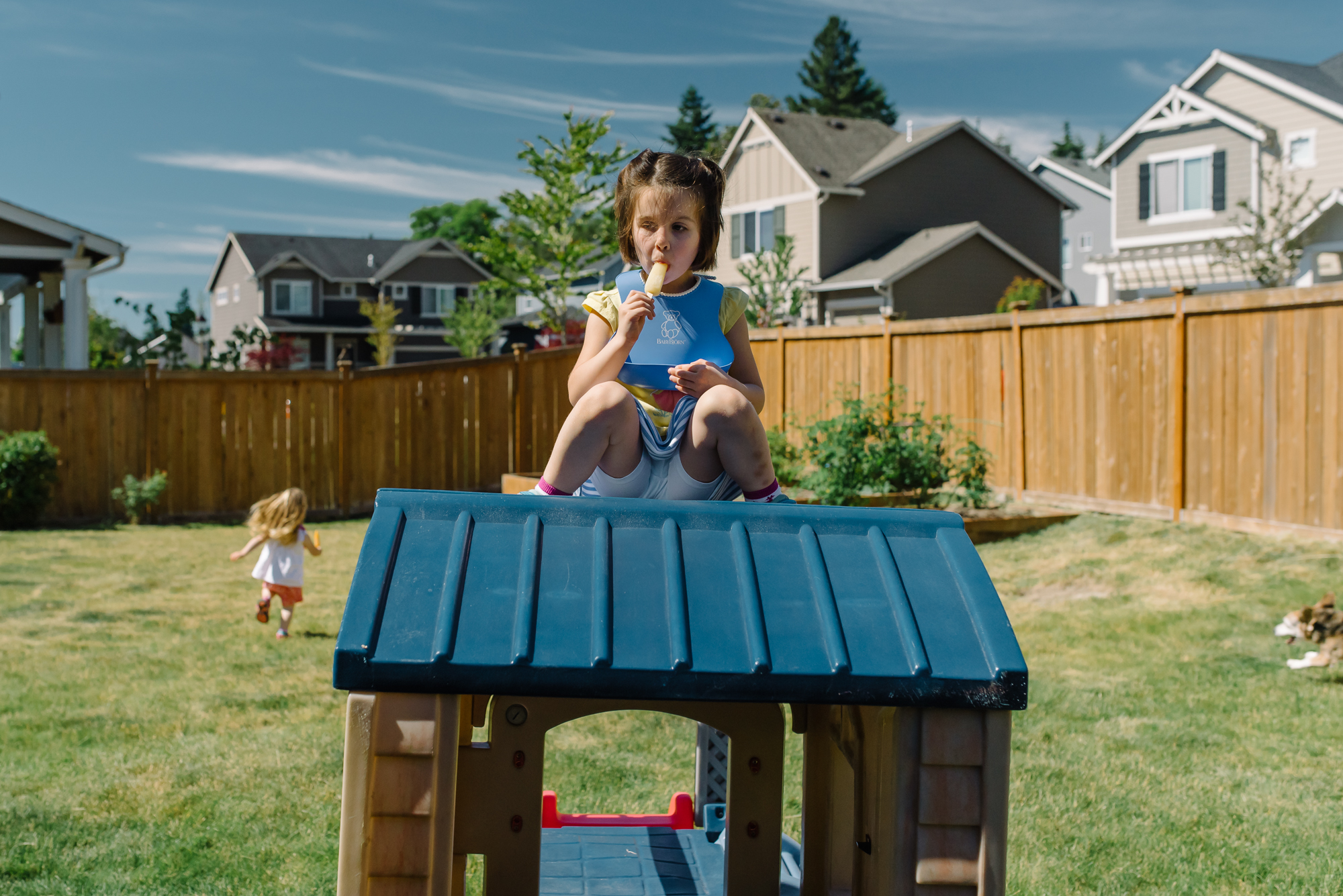 Erika Roa - girl eats popsicle atop playhouse 