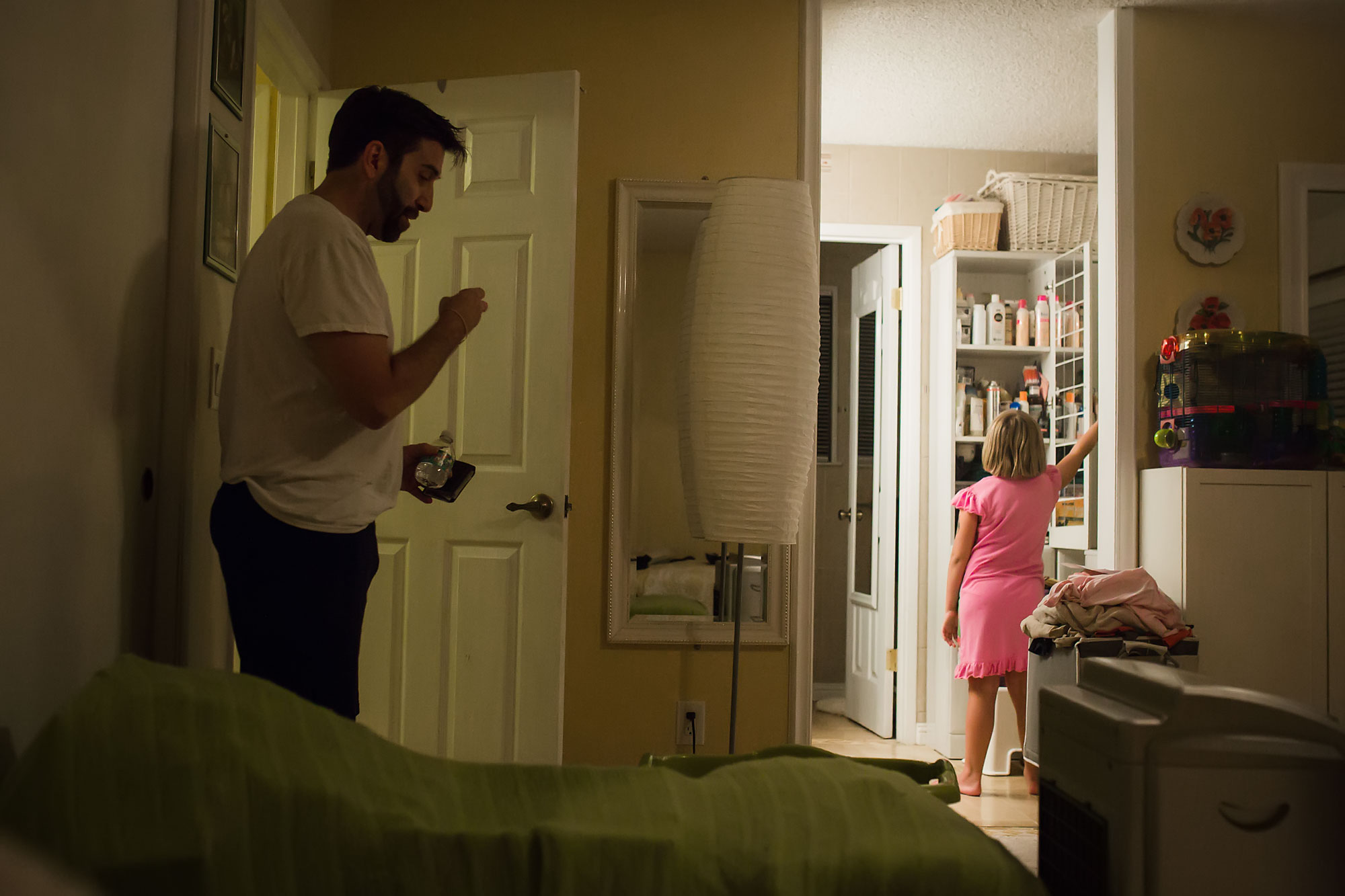 girl stands at pantry while father waits - Documentary Family Photography