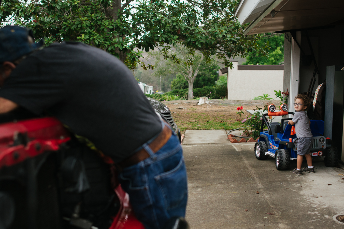 boy mimics dad working on car - Documentary Family Photography