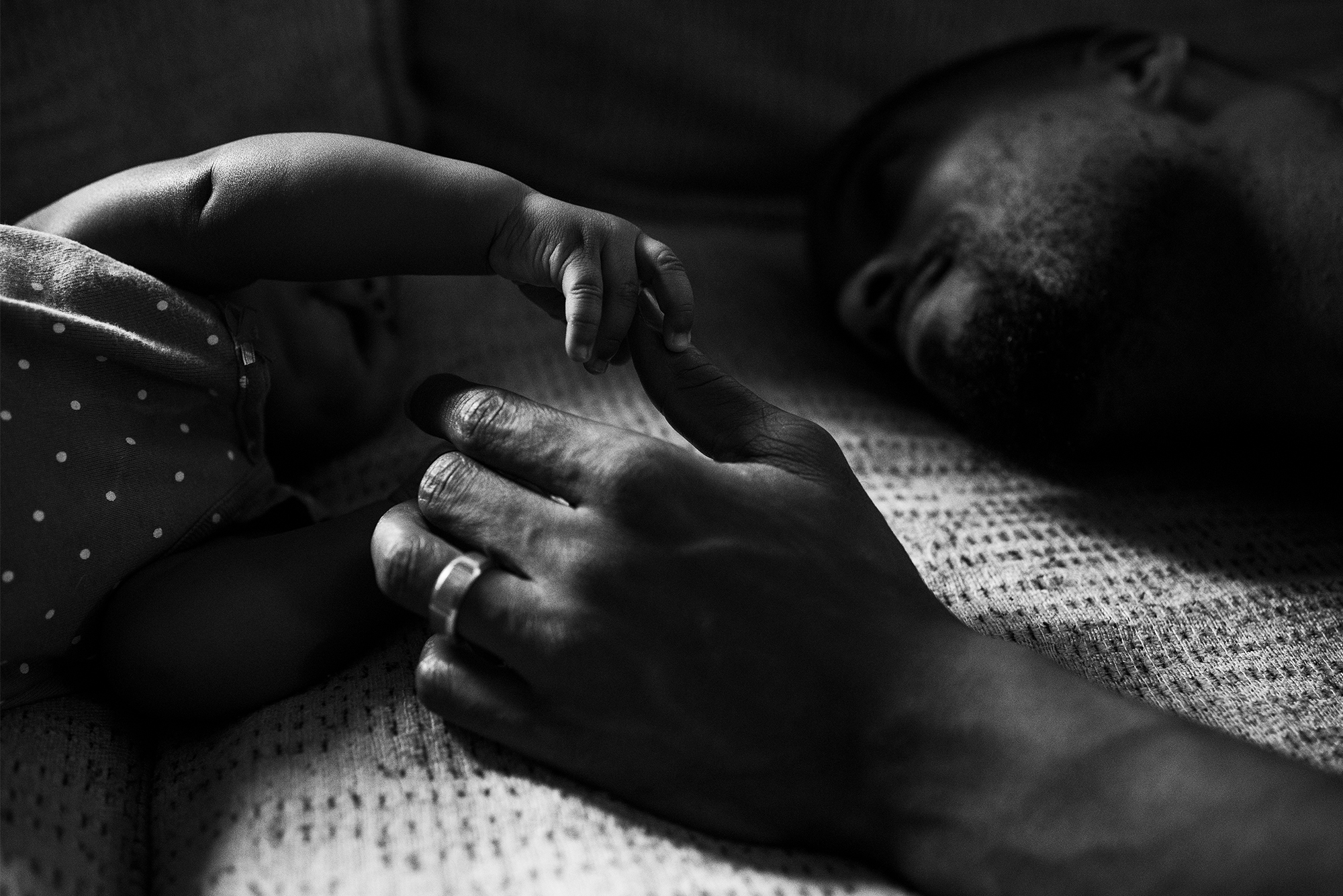 father holds baby hand - Documentary Family Photography