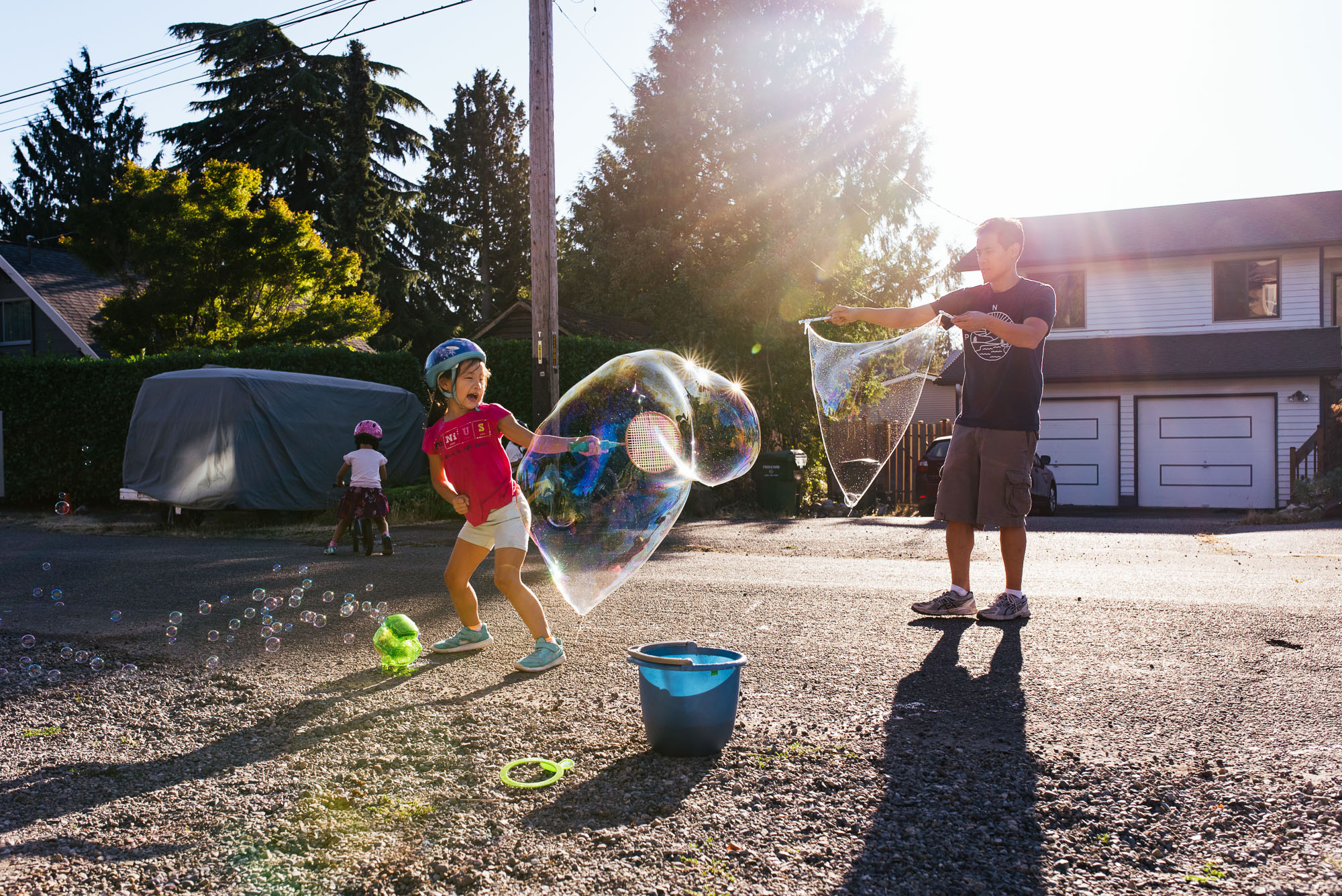 kids blow giant bubbles with Dad - Documentary Family Photography