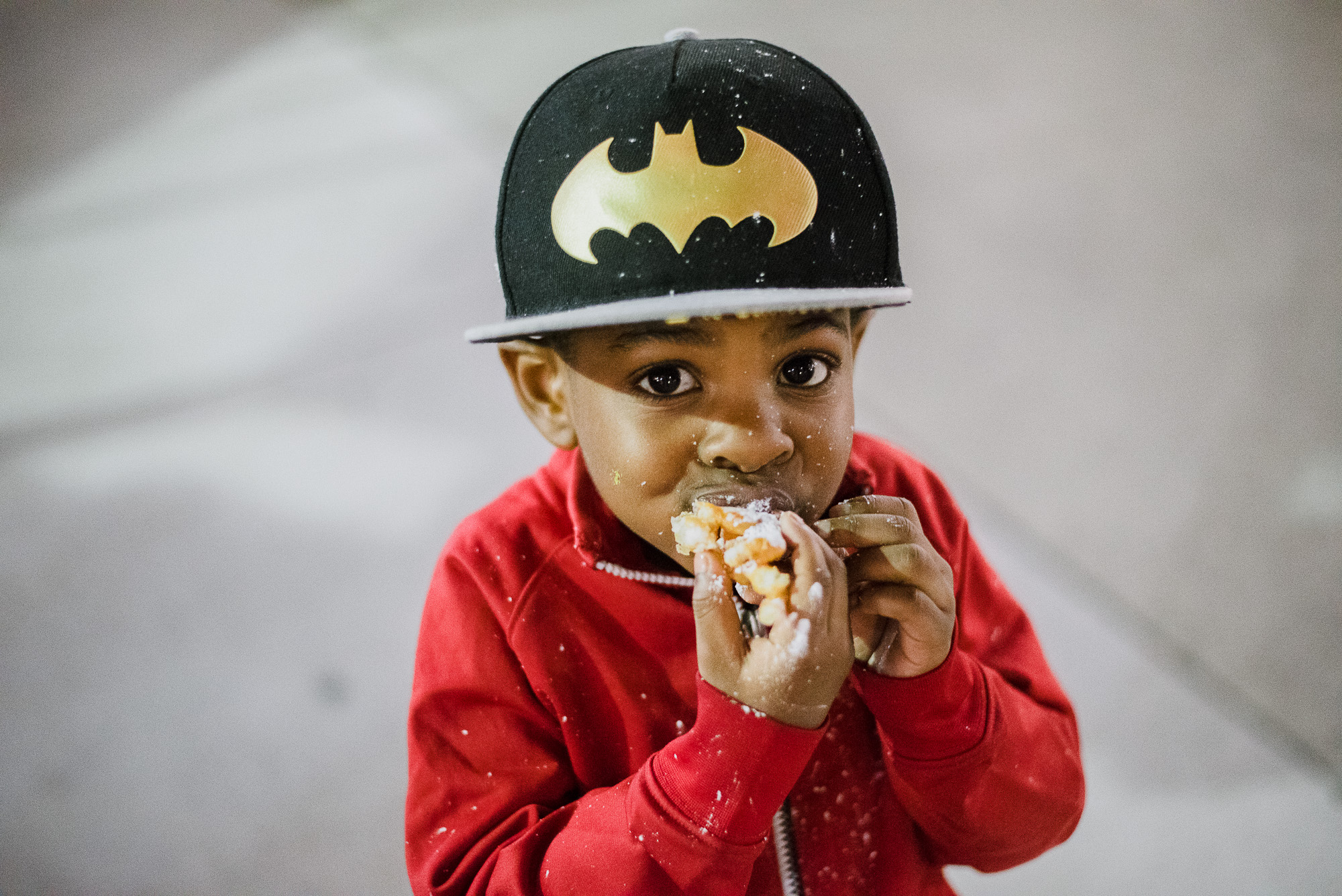 boy eating while wearing ball cap -Documentary Family Photography