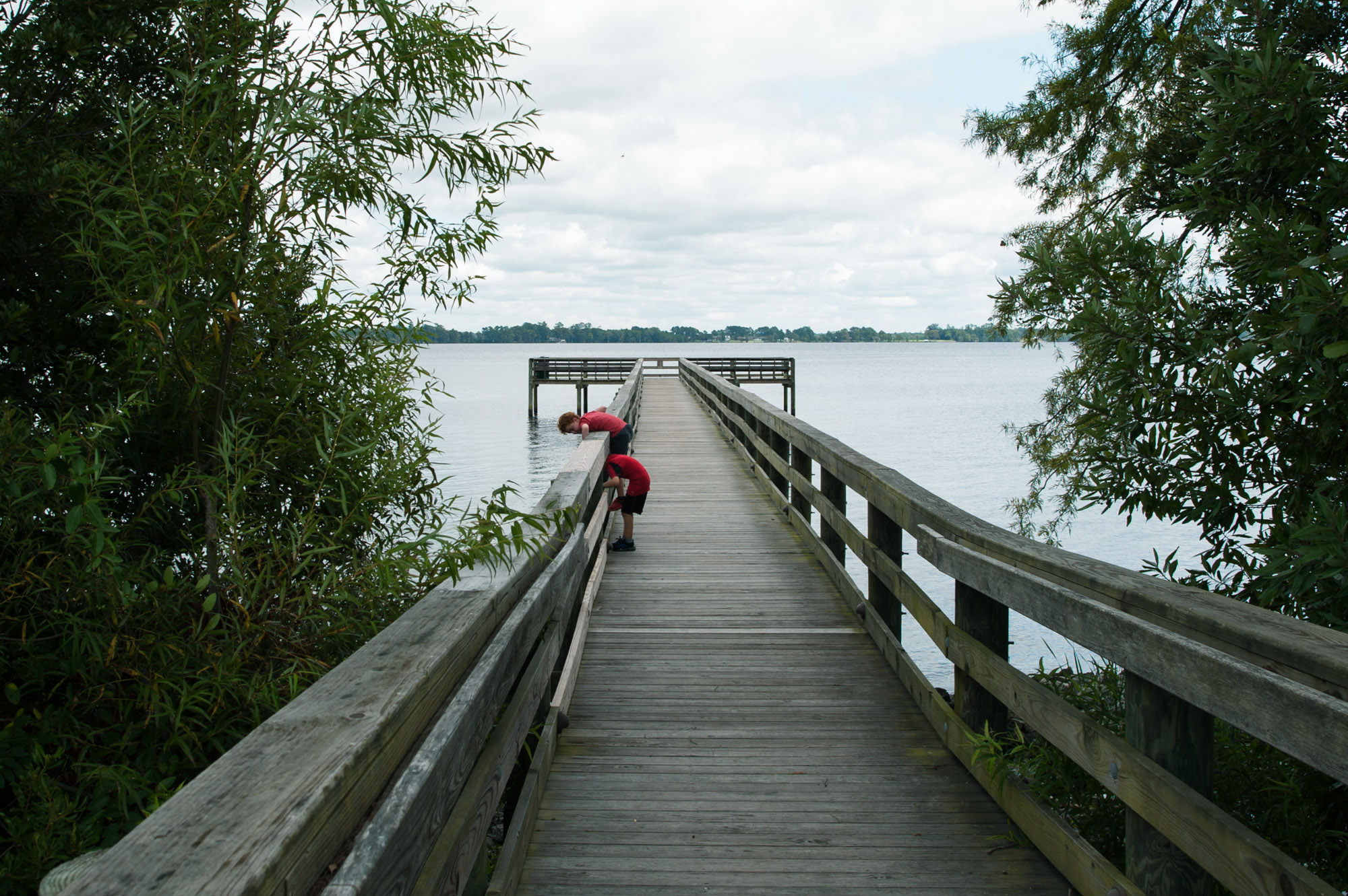 child leaning over dock -Documentary Family Photography