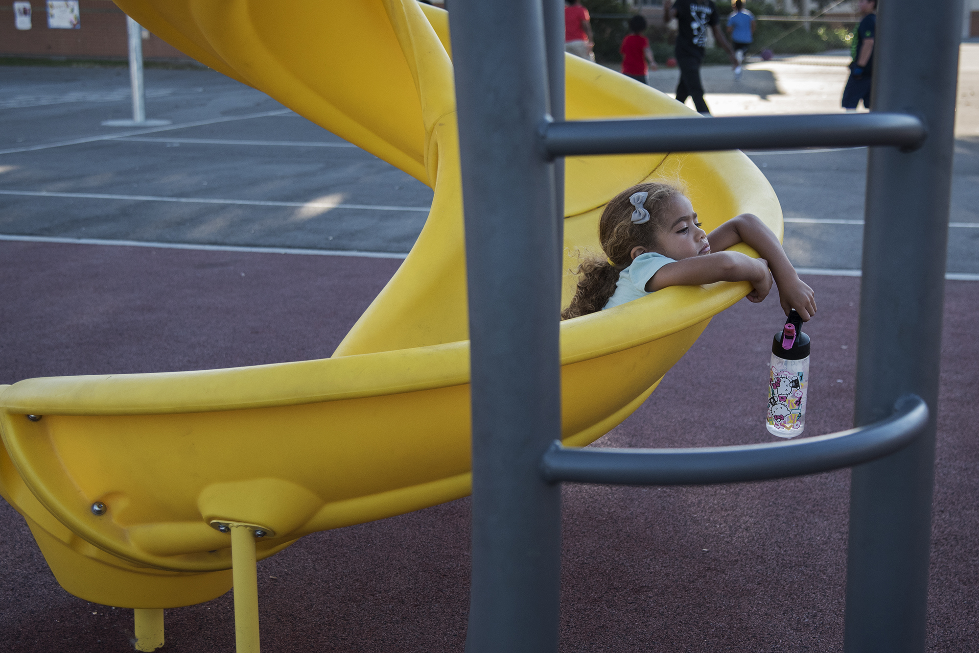tired girl lounging in playground slide -Documentary Family Photography