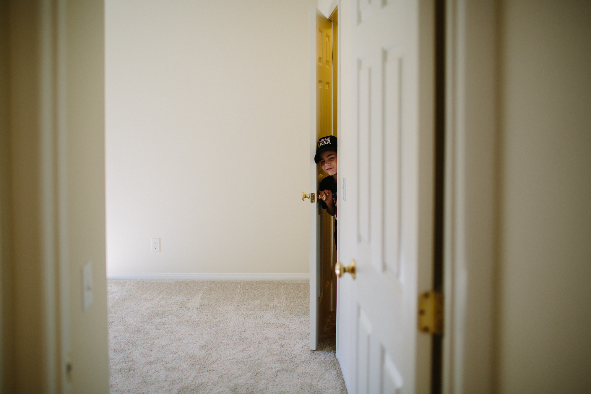 kid peeks from closet - Documentary Family Photography