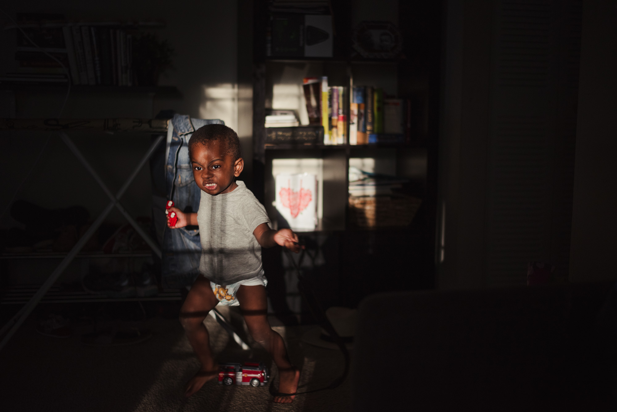 boy in light spot in pantry - documentary family photography