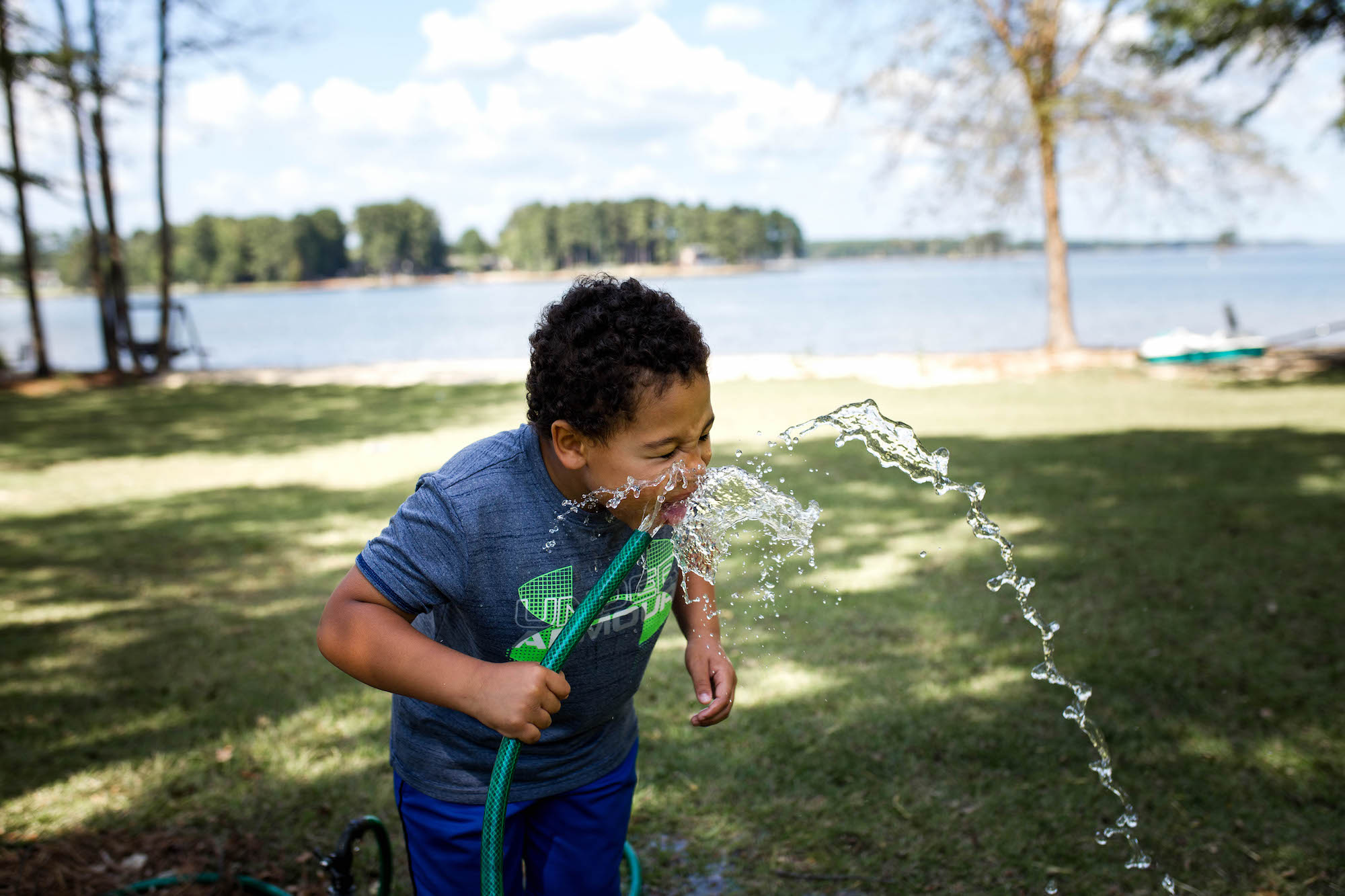 boy drinks from hose - documentary family photography