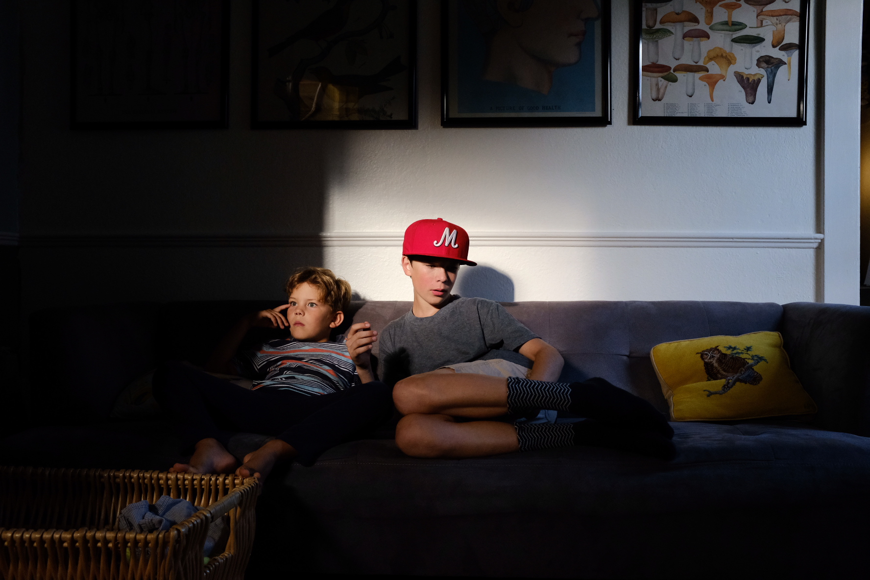 kids sit in light spot on couch - documentary family photography