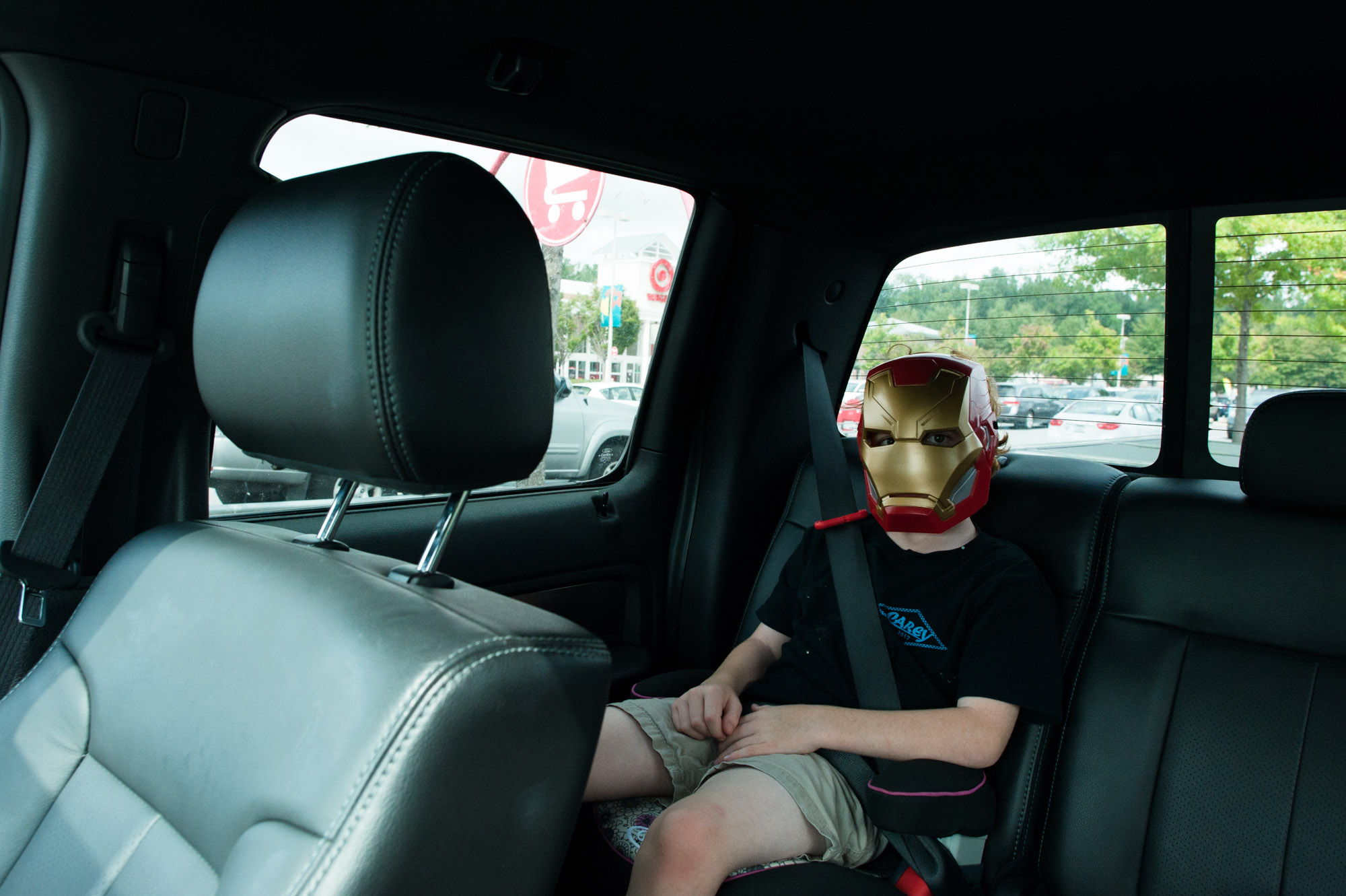 boy with iron man mask in car - documentary family photography