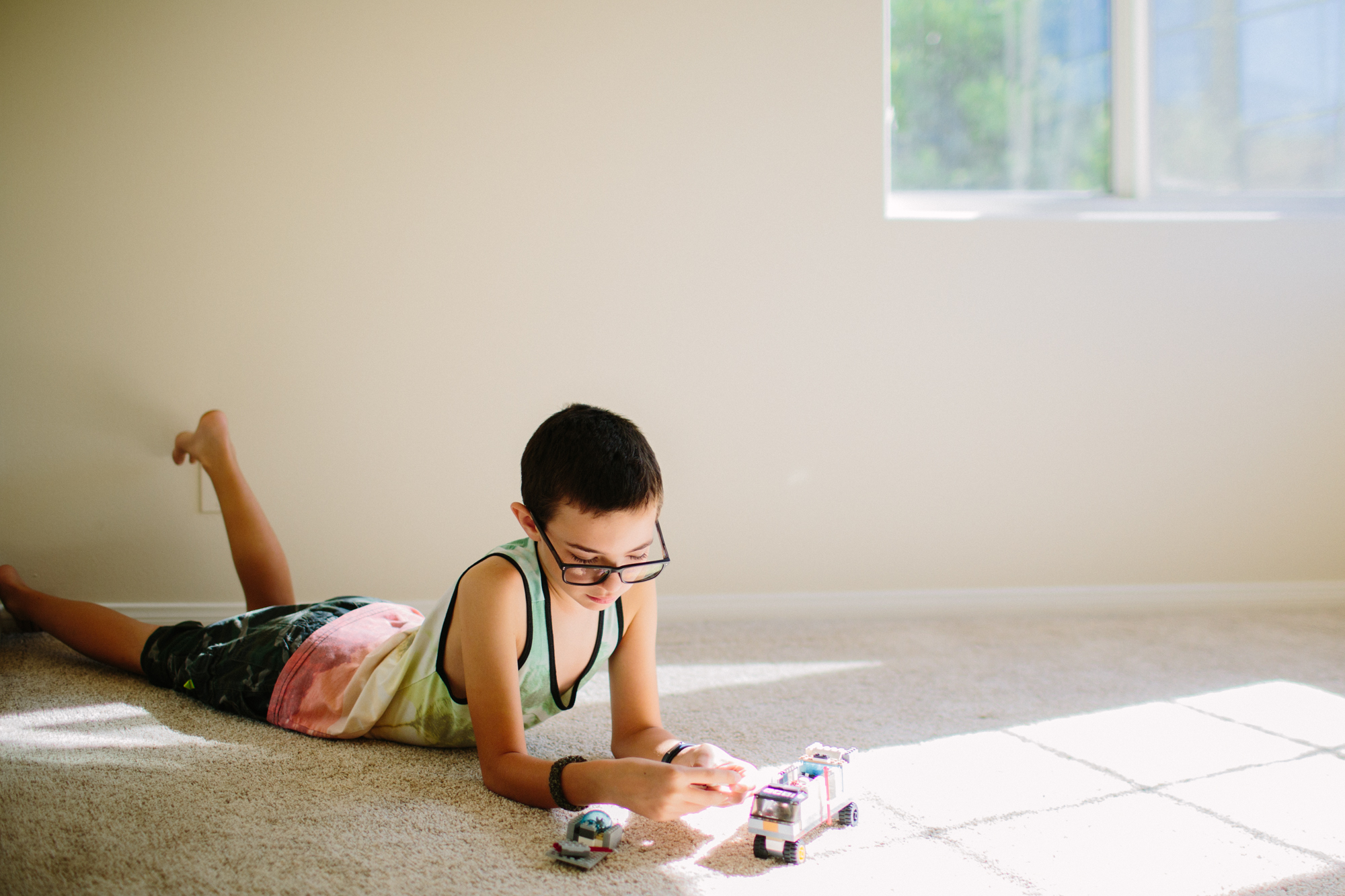 boy plays with Legos in empty room - documentary family photography