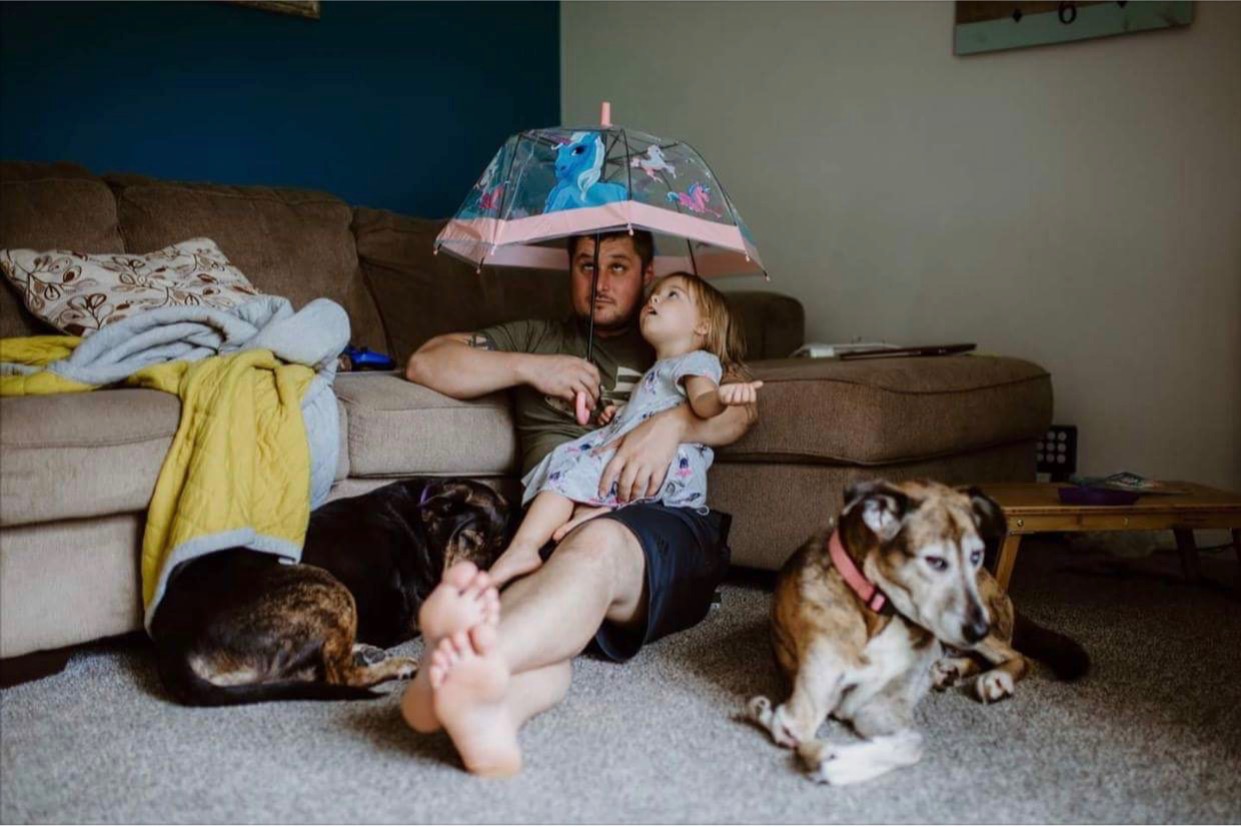father with daughter under umbrella inside - Documentary Family Photography