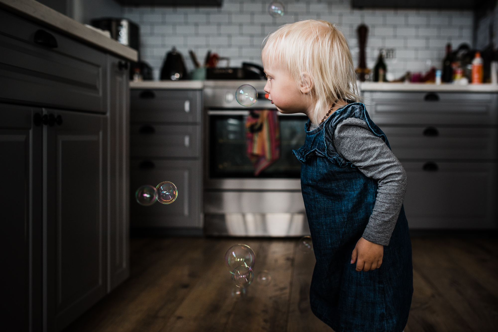 girl with bubbles in kitchen - documentary family photography