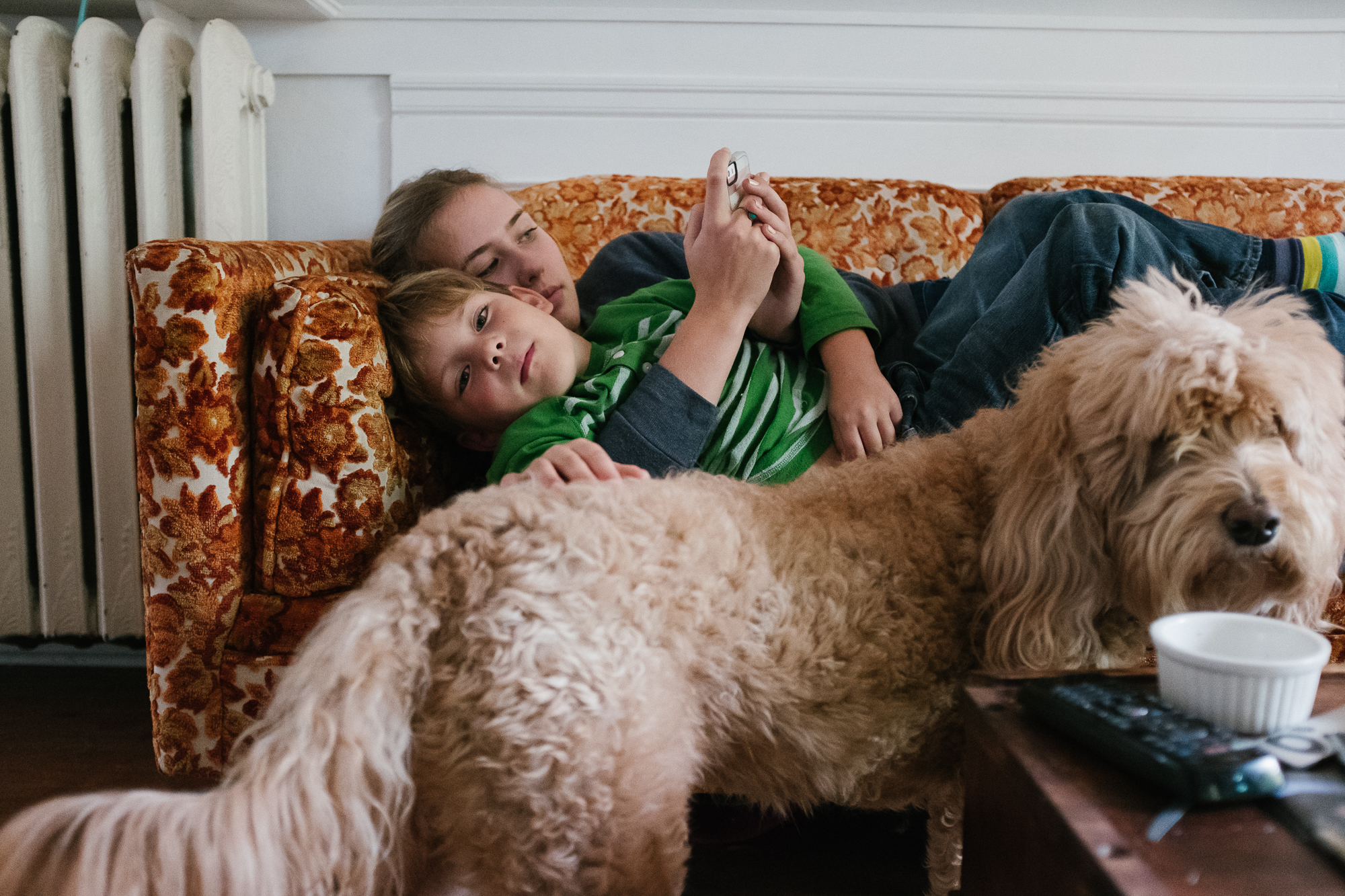 brother and sister snuggled on couch - documentary family photography