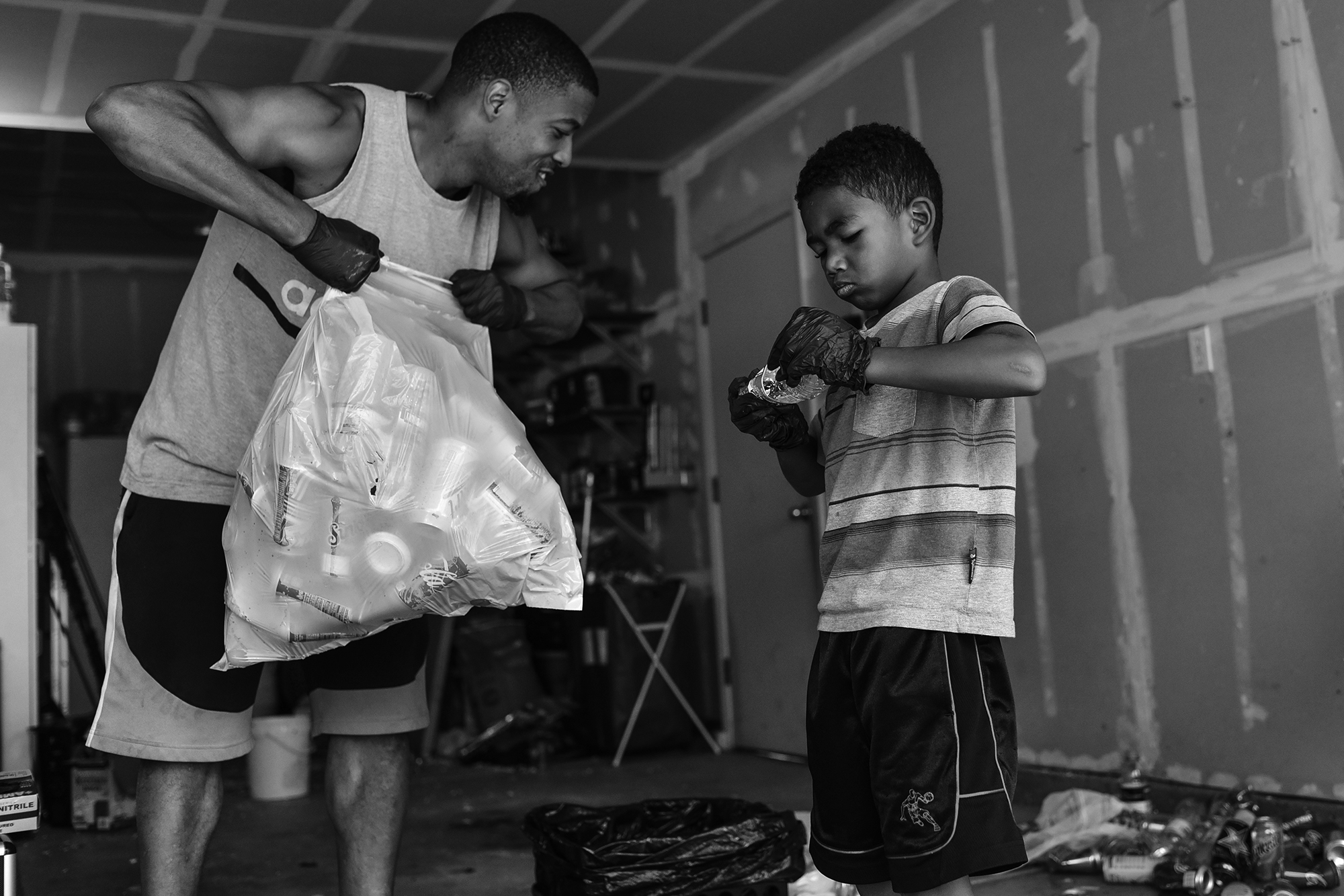 boy helps father with recycling  - documentary family photography