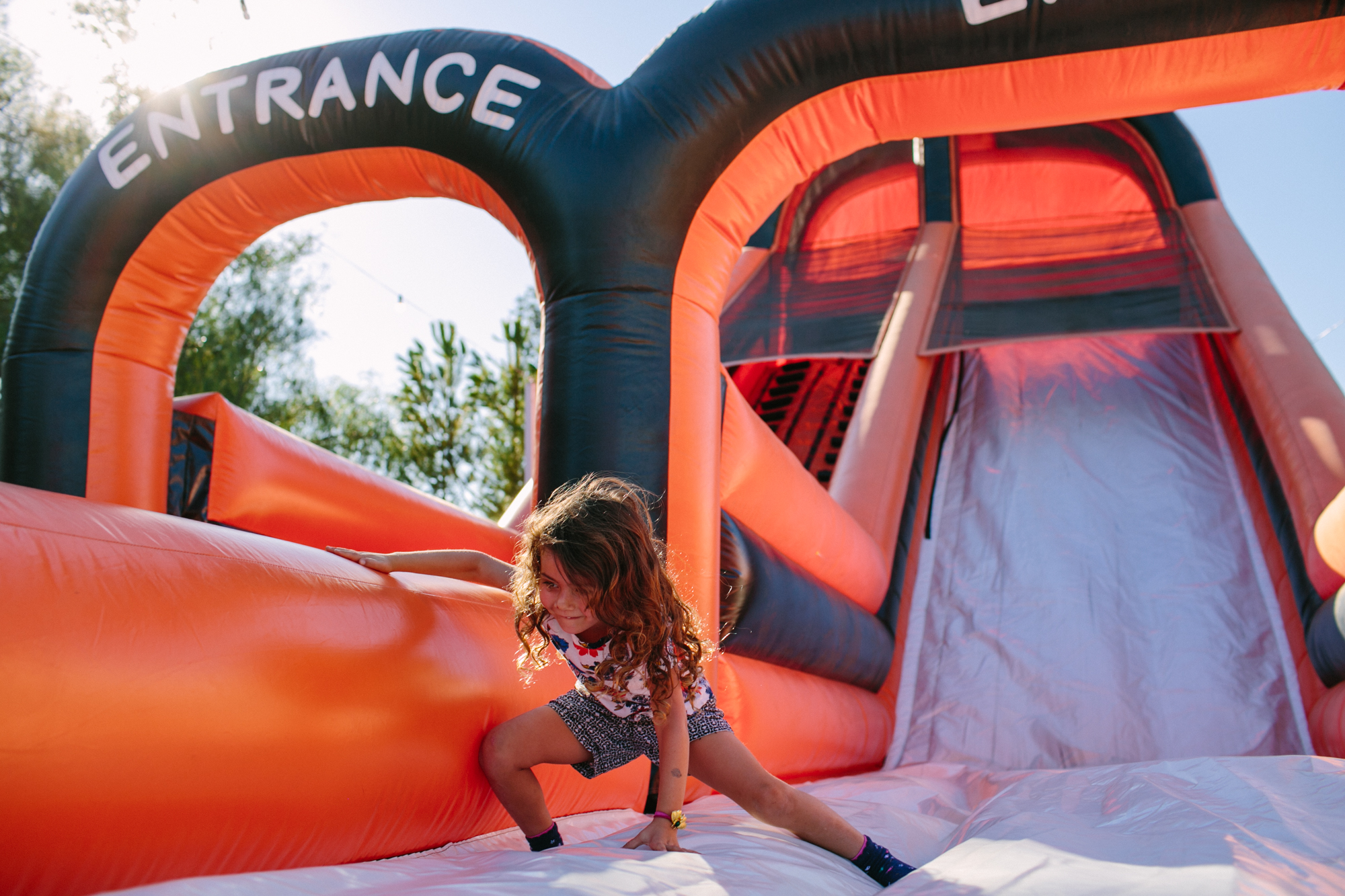 girl on blow up slide - documentary family photography