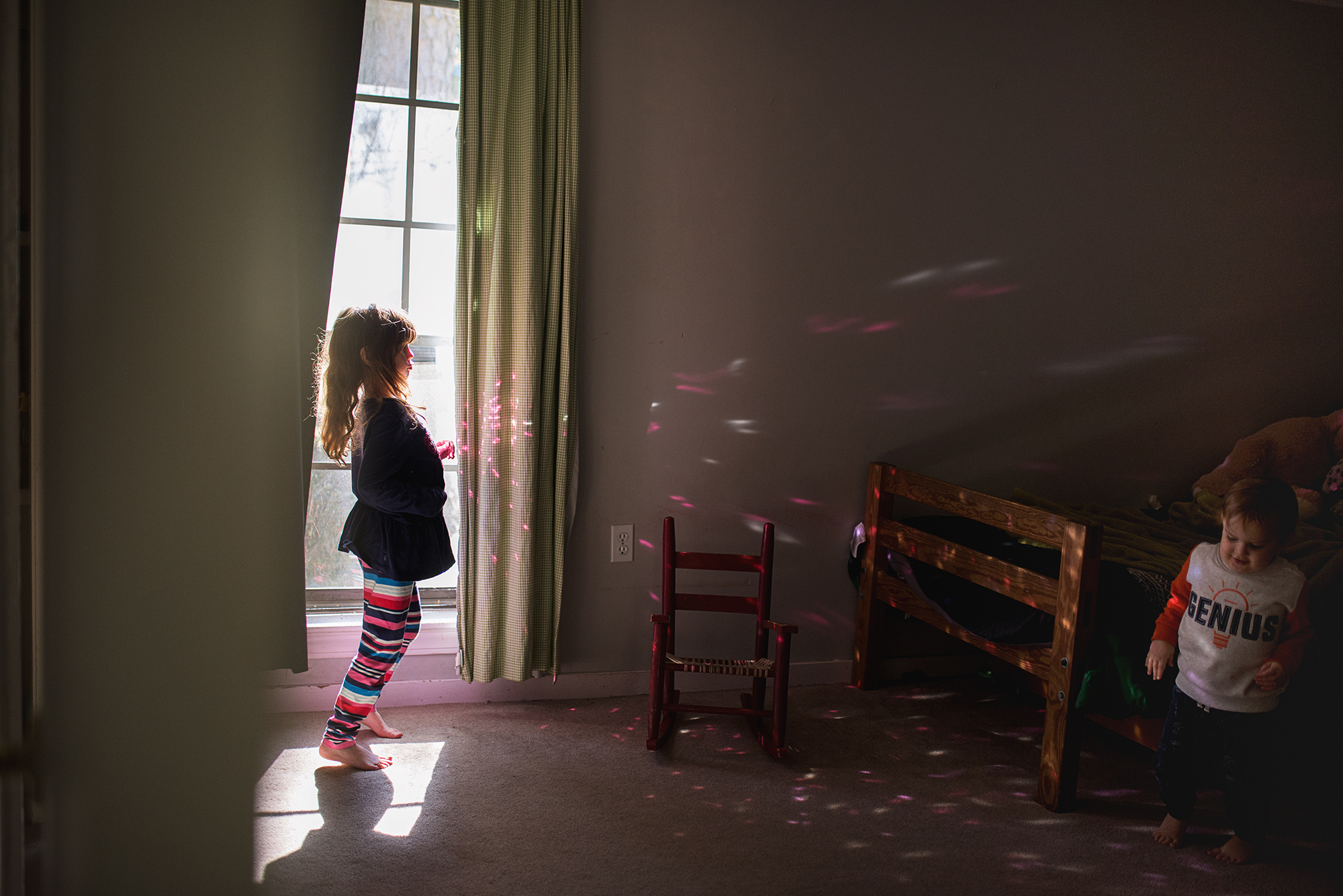 child in window - documentary family photography