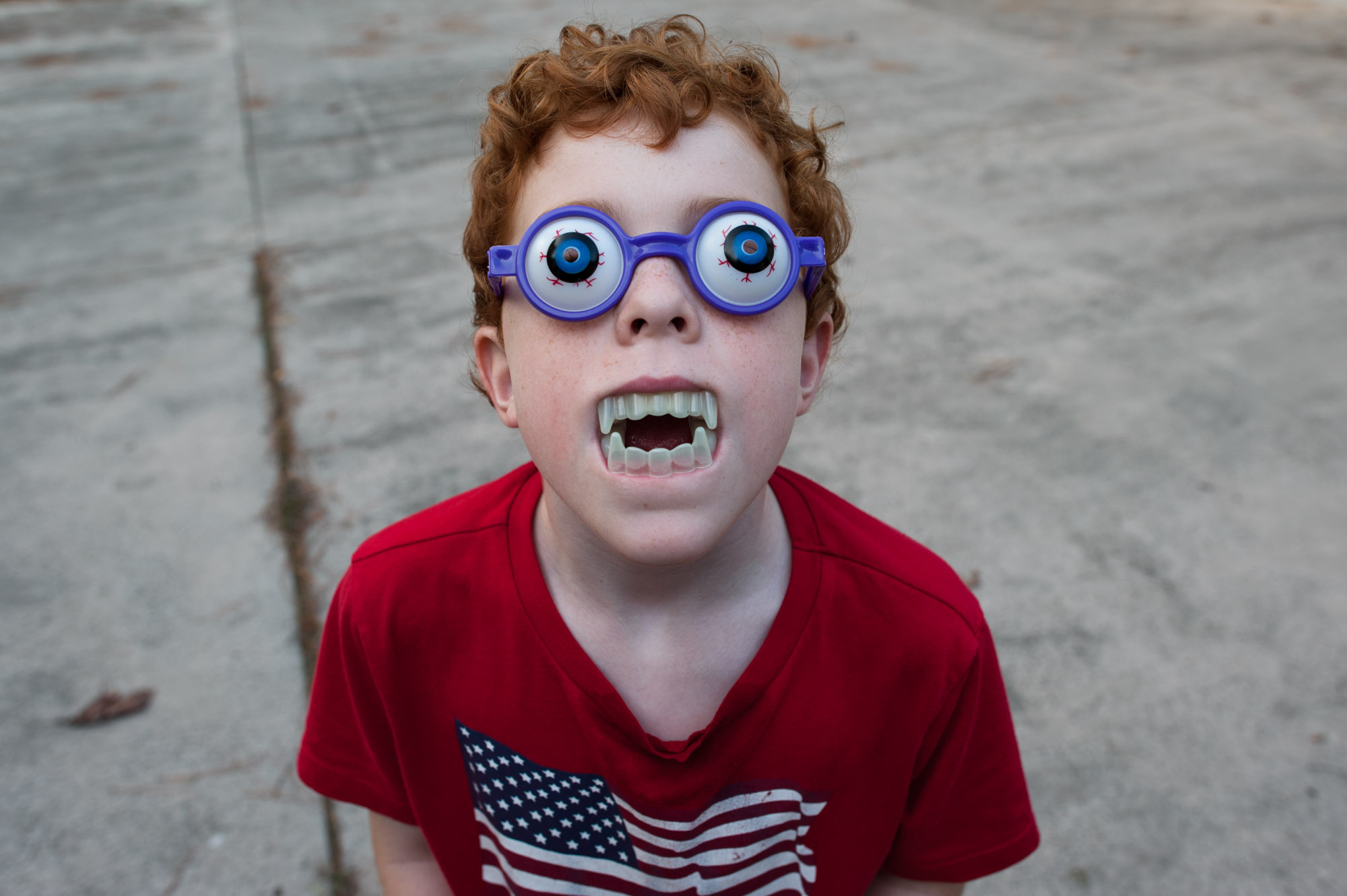 boy with vampire teeth and novelty glasses - documentary family photography