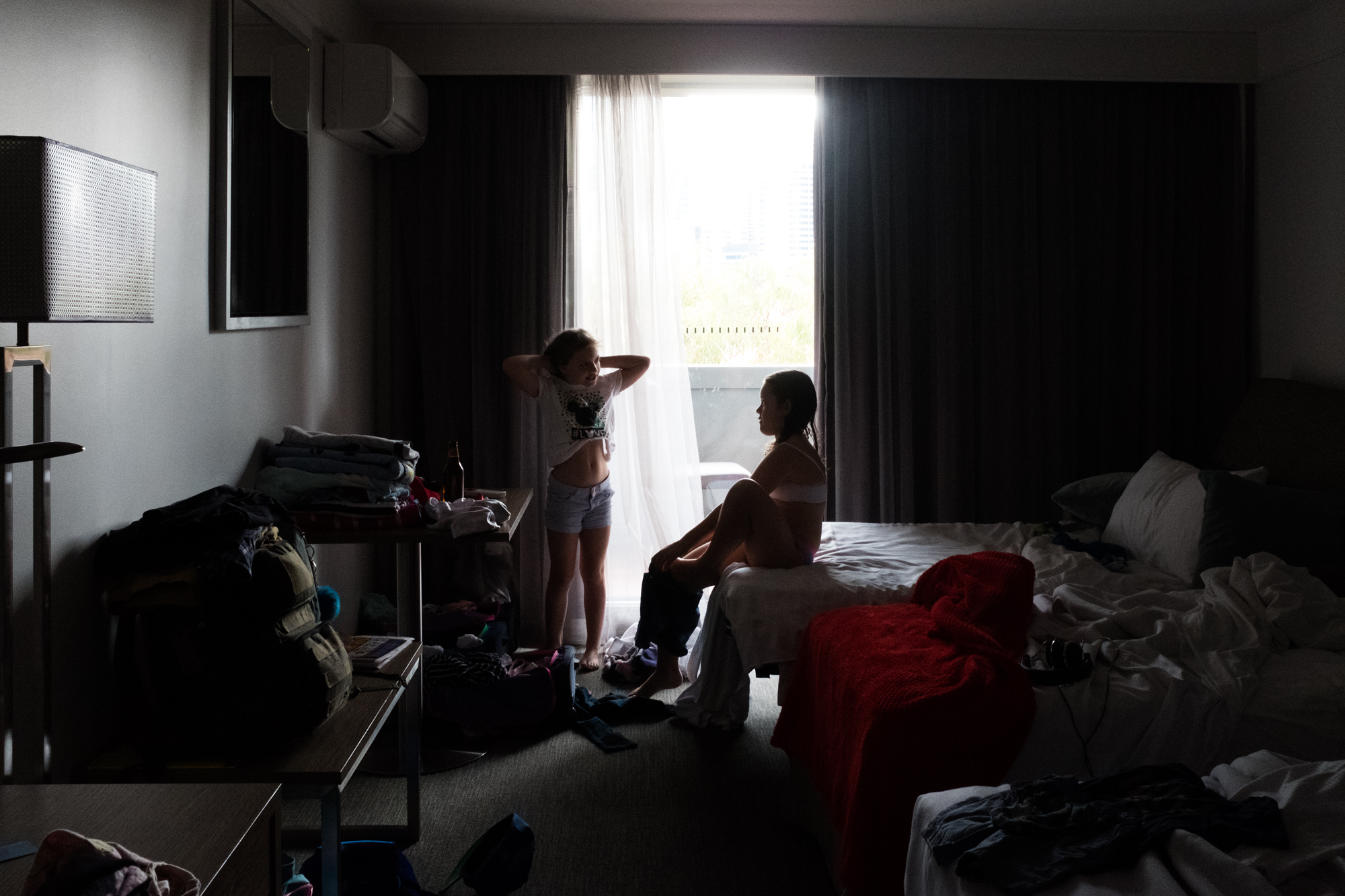 kids at hotel room window -documentary family photography