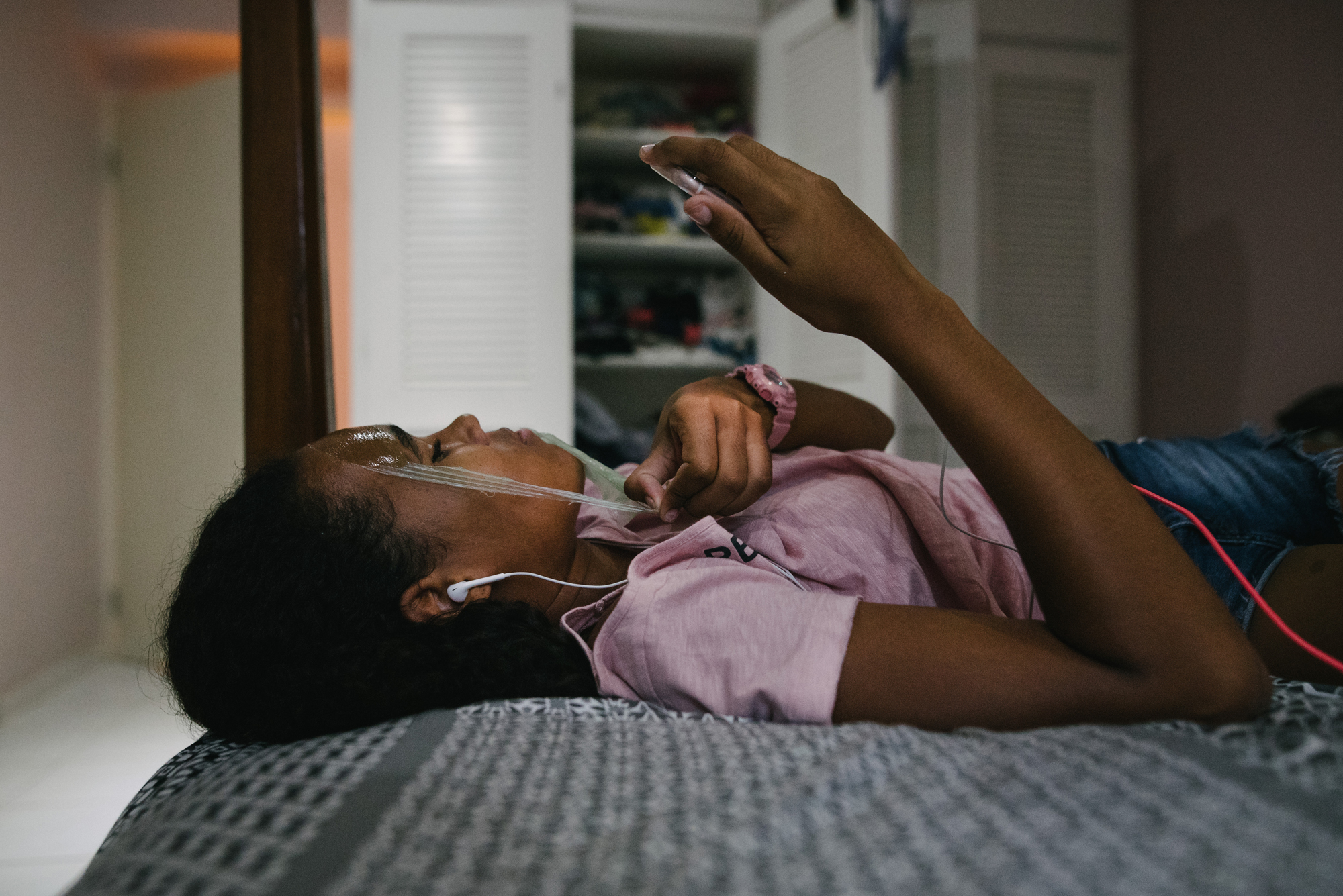 girl on bed with ear buds - Documentary Family Photography