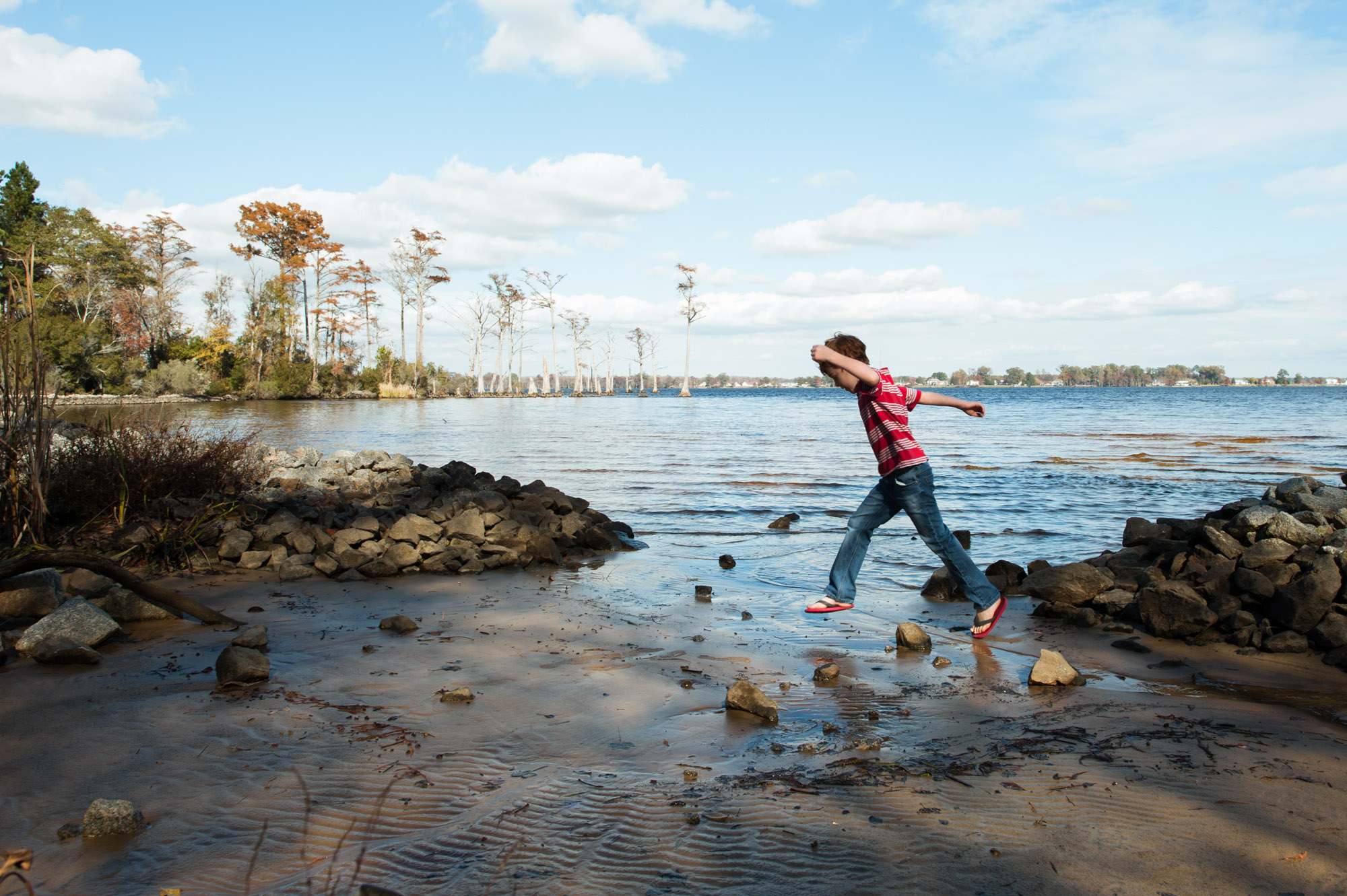 boy jumps over water - Documentary Family Photography