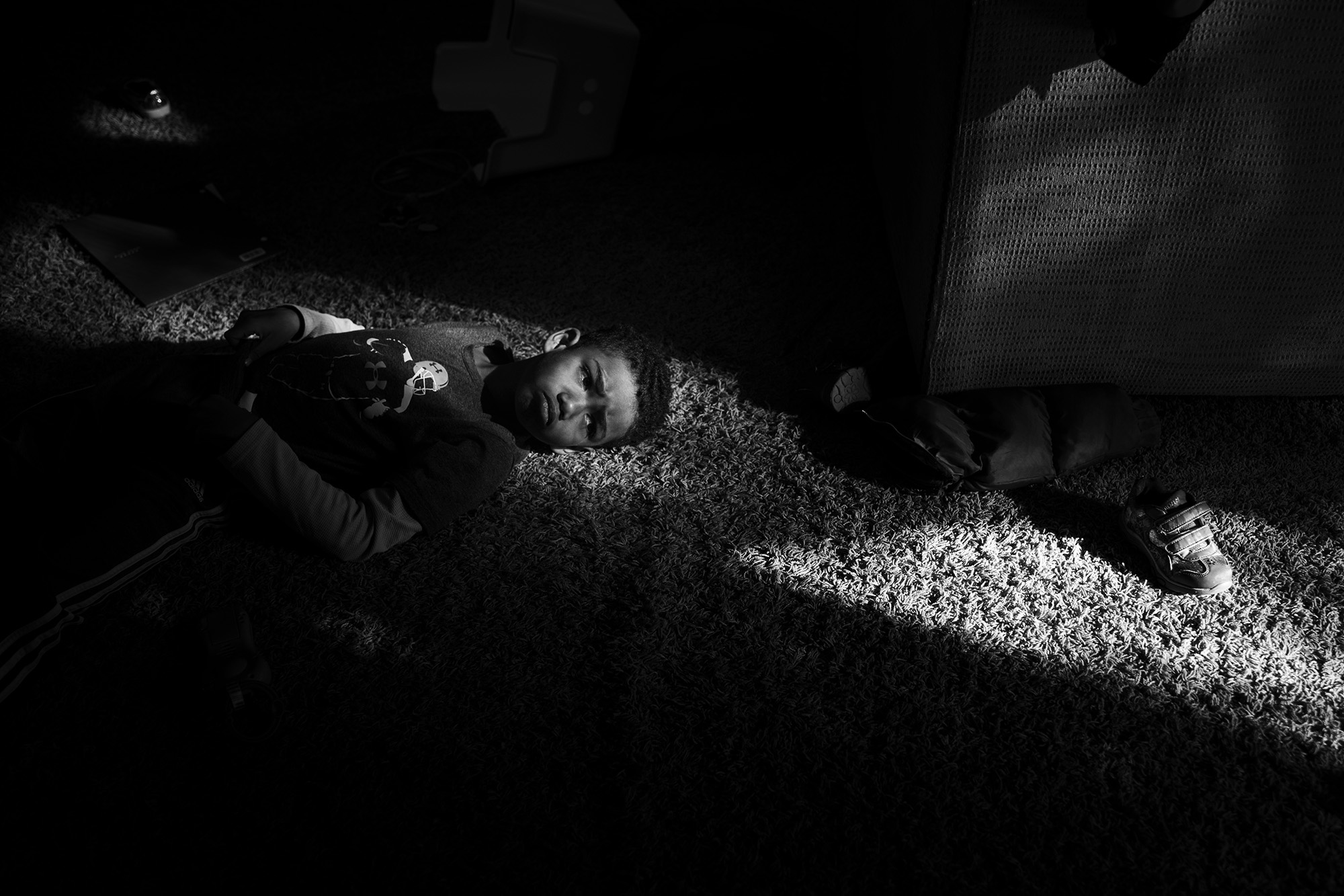 child laying in patch of sunlight - Documentary Family Photography