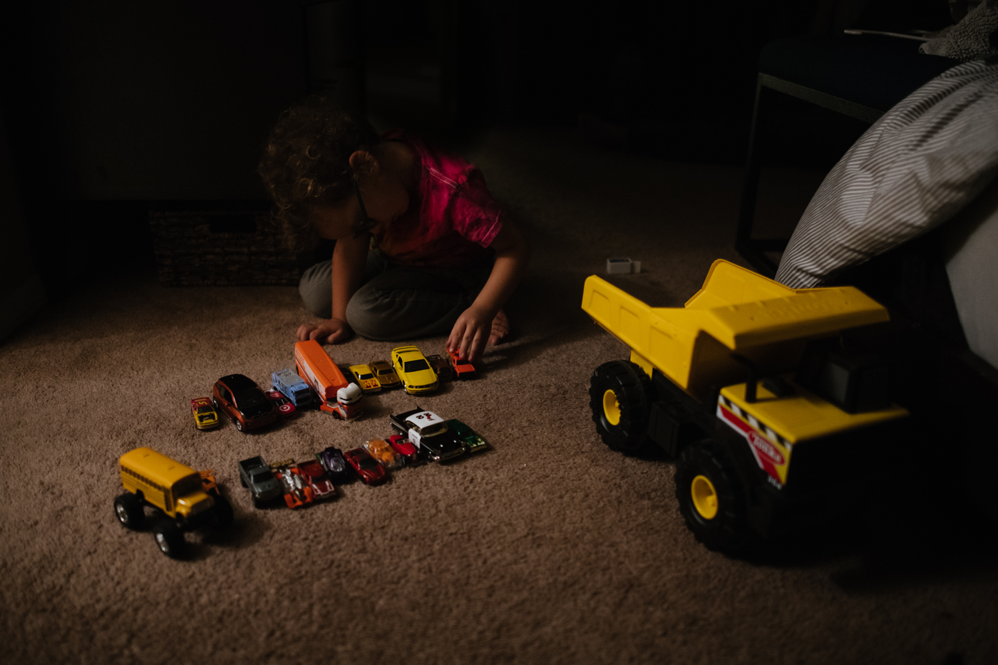 child lining up toy cars - Documentary Family Photography