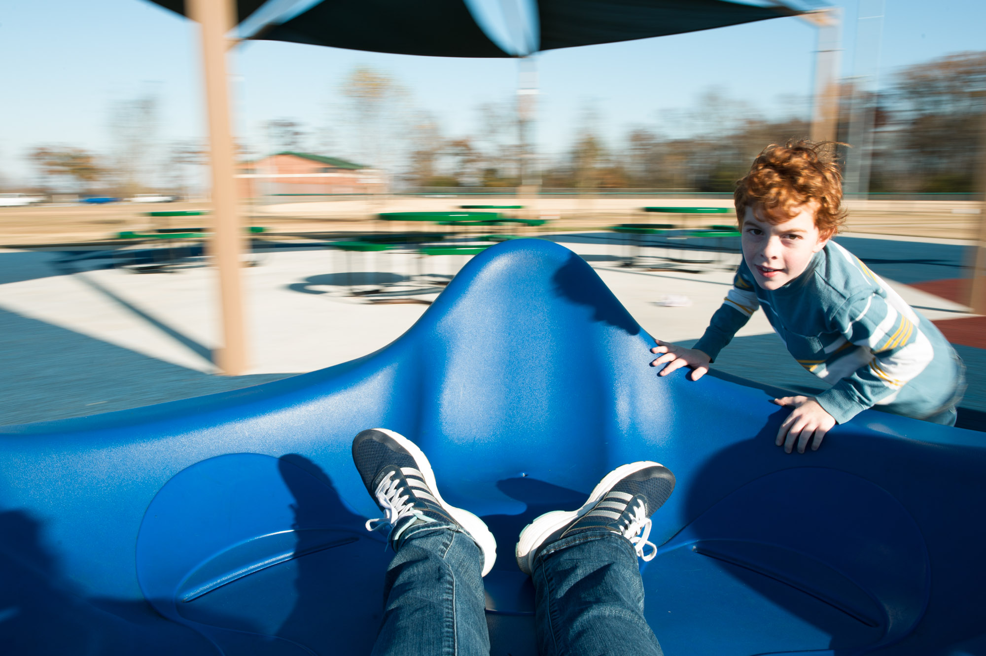 kid spinning playground equipment - documentary family photography