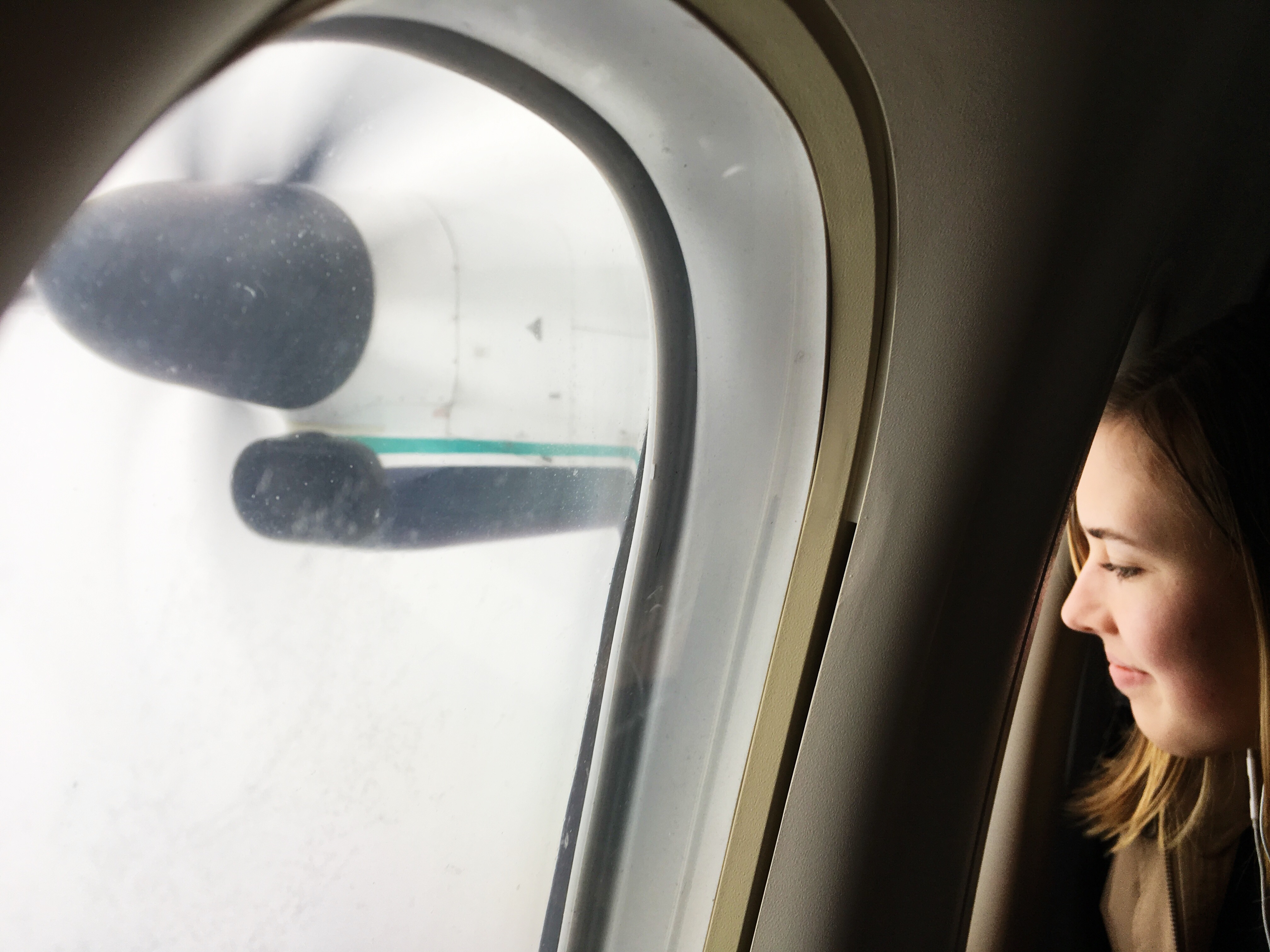 girl looks out airplane window - Documentary family photography
