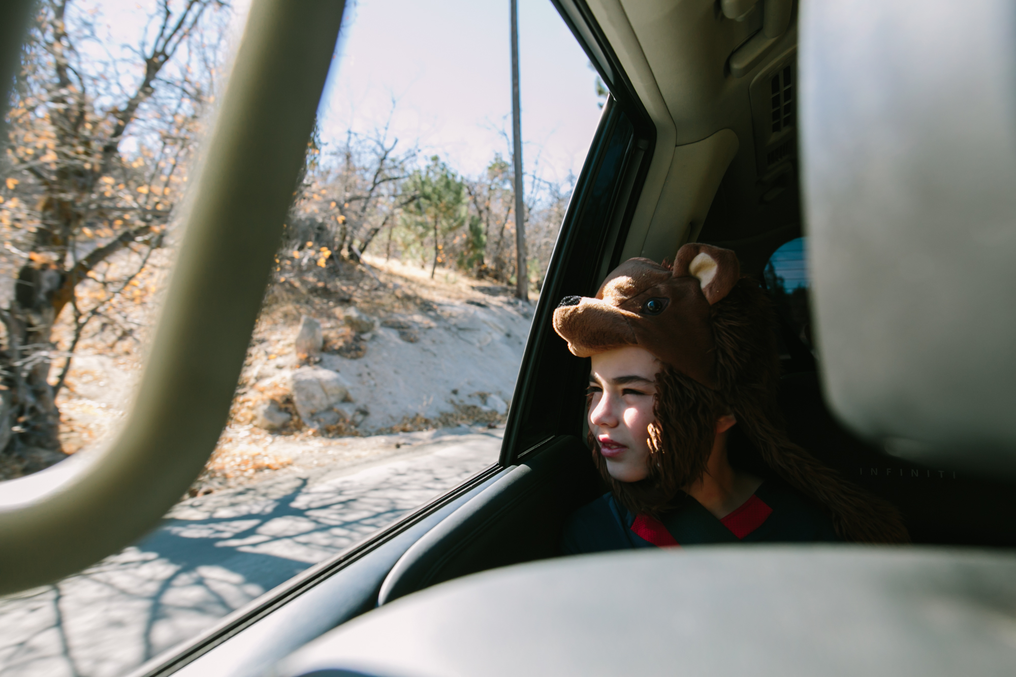 boy in witer gear looks out car window -Documentary family photography