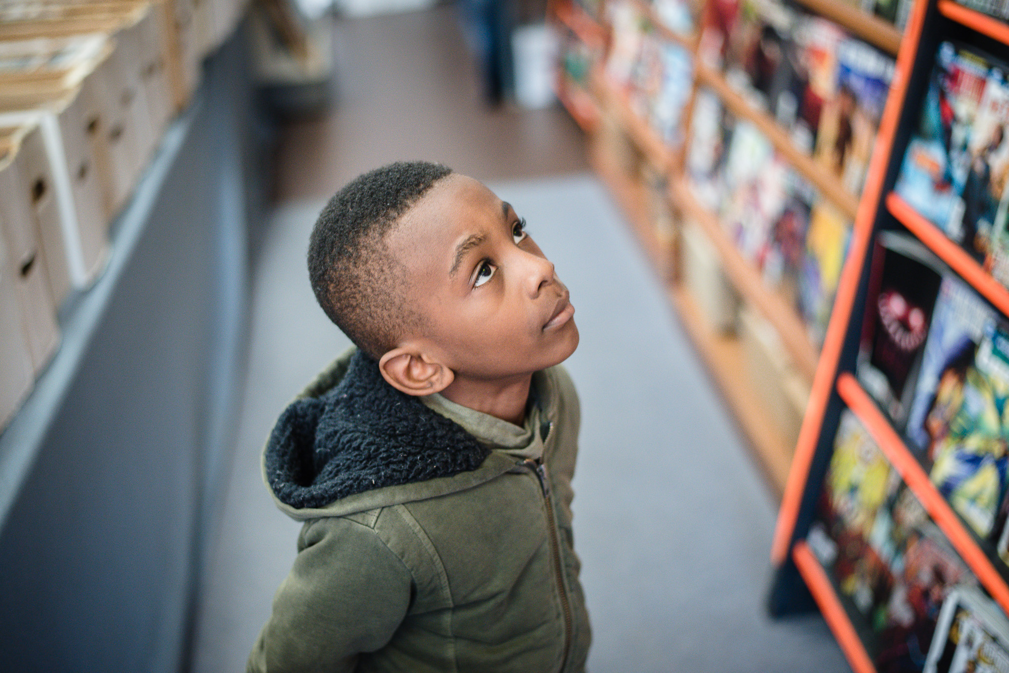 boy looking up at shelf - Documentary Family Photography