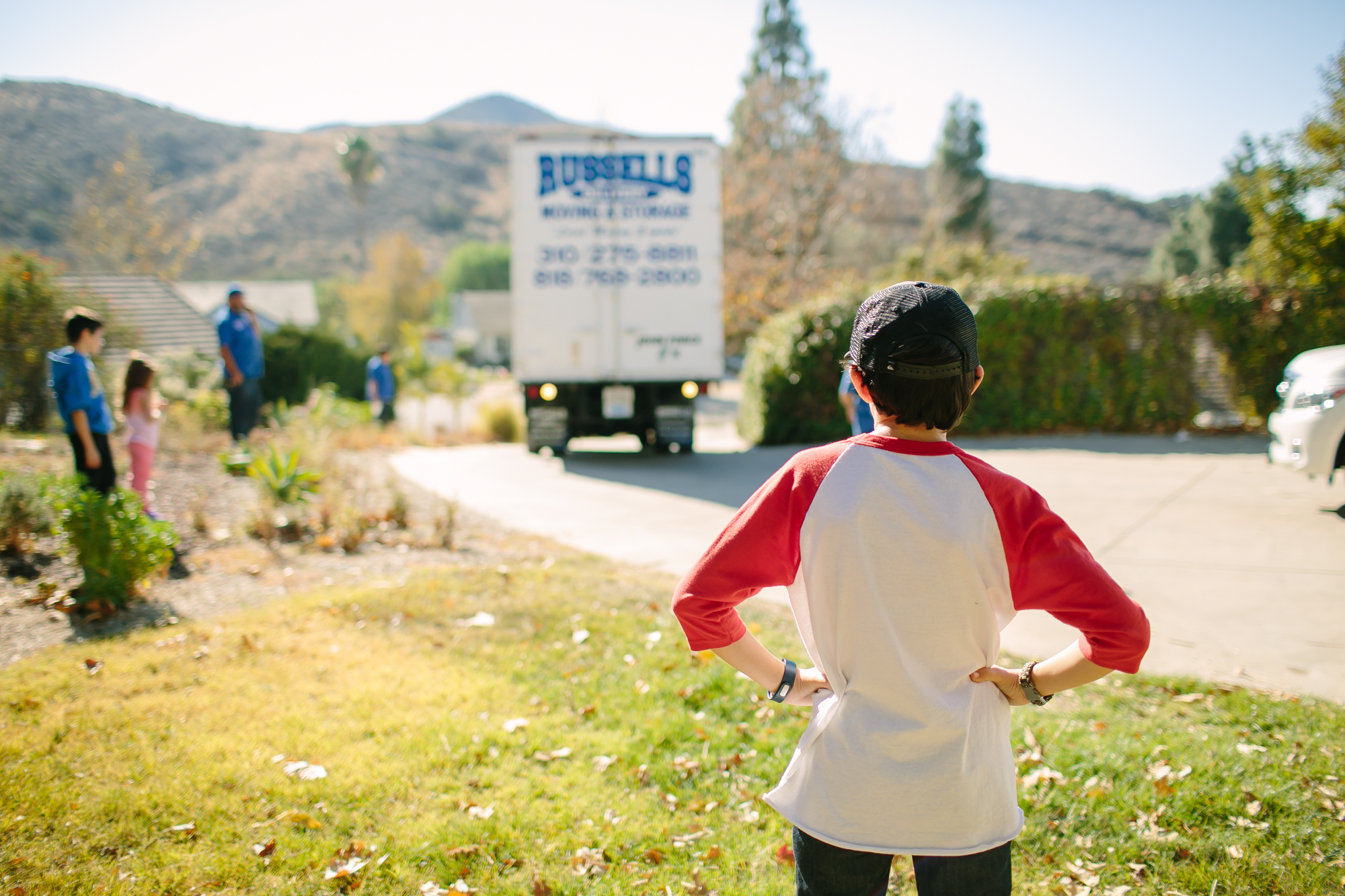boy watching moving truck leave - Documentary Family Photography