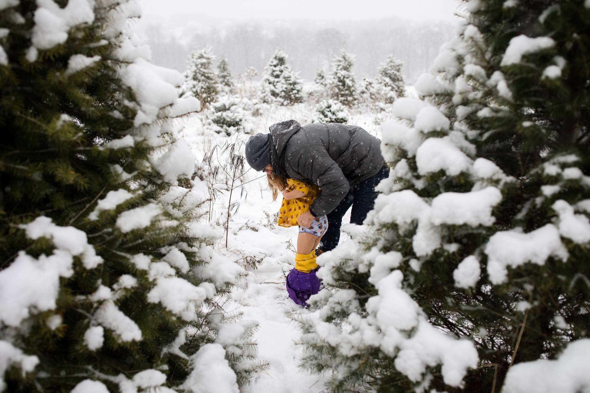 parent helps child with pants in snow - Documentary Family Photography