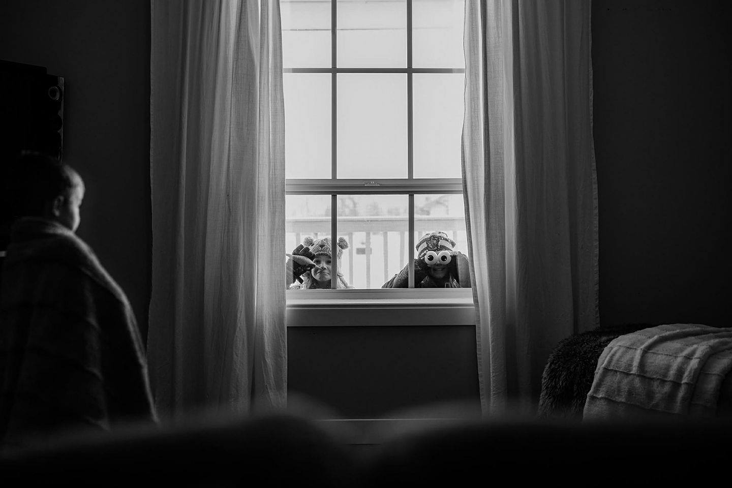 kids peer in window from outside - Documentary Family Photography