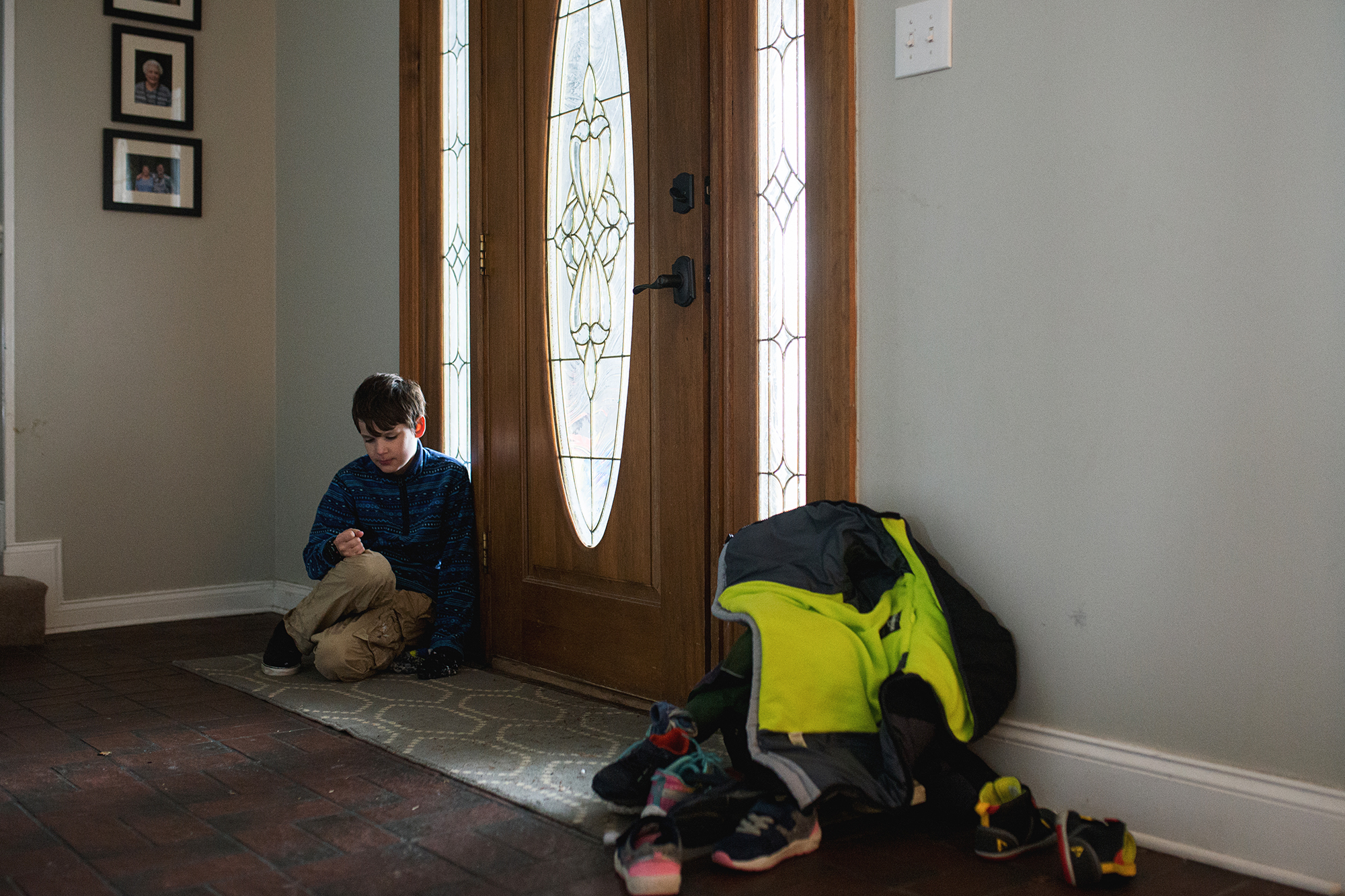 Child sits near front door - Documentary Family Photography