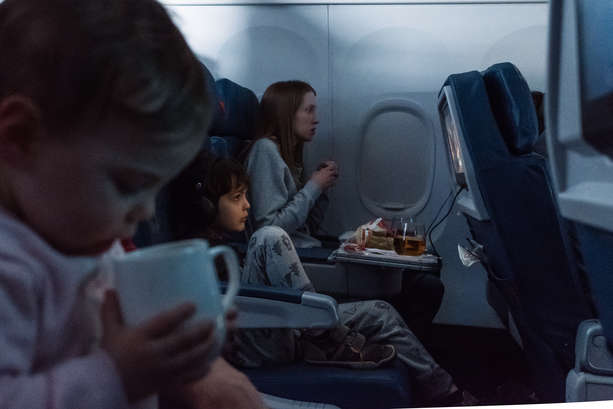boy watching TV on plane - Documentary Family Photography