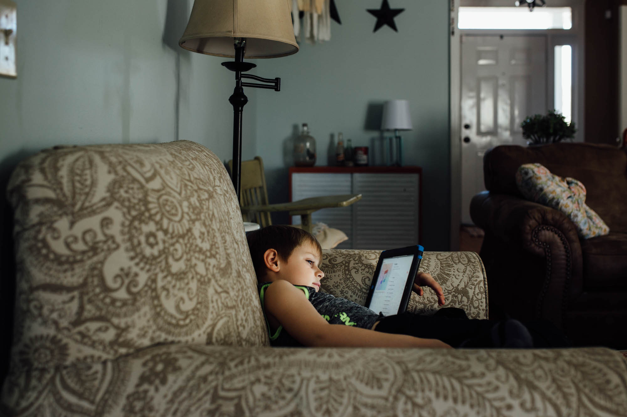 boy with tablet on couch - Documentary Family Photography